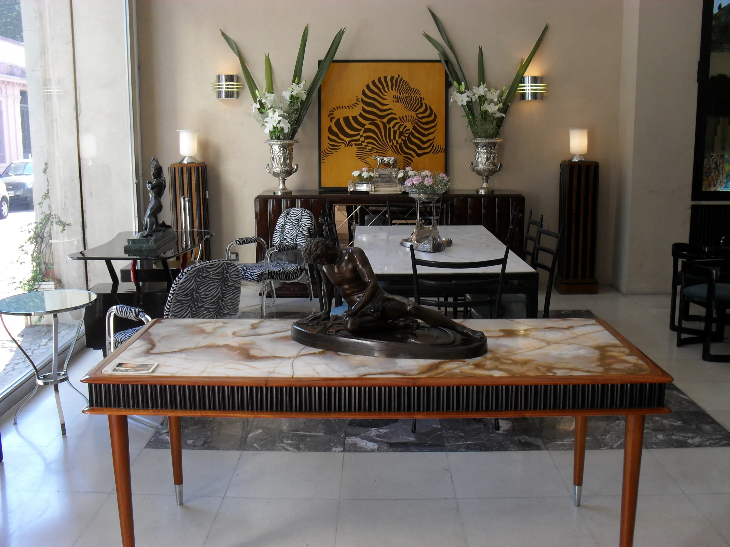 View of an antiques store Balcarce 1084 in San Telmo, featuring elegant decor, sculptures, and plants.