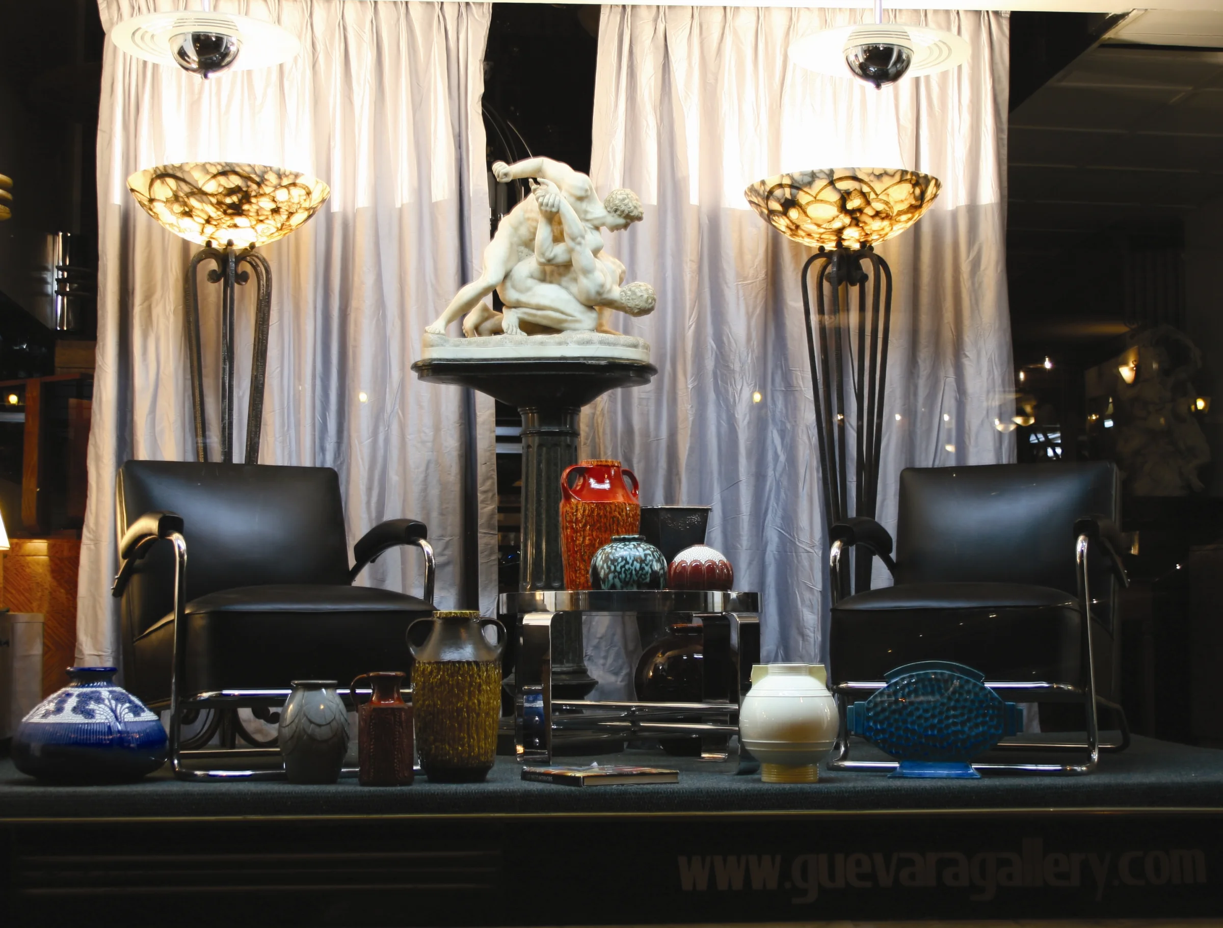 Antique sculpture in a showcase with lamps and chairs