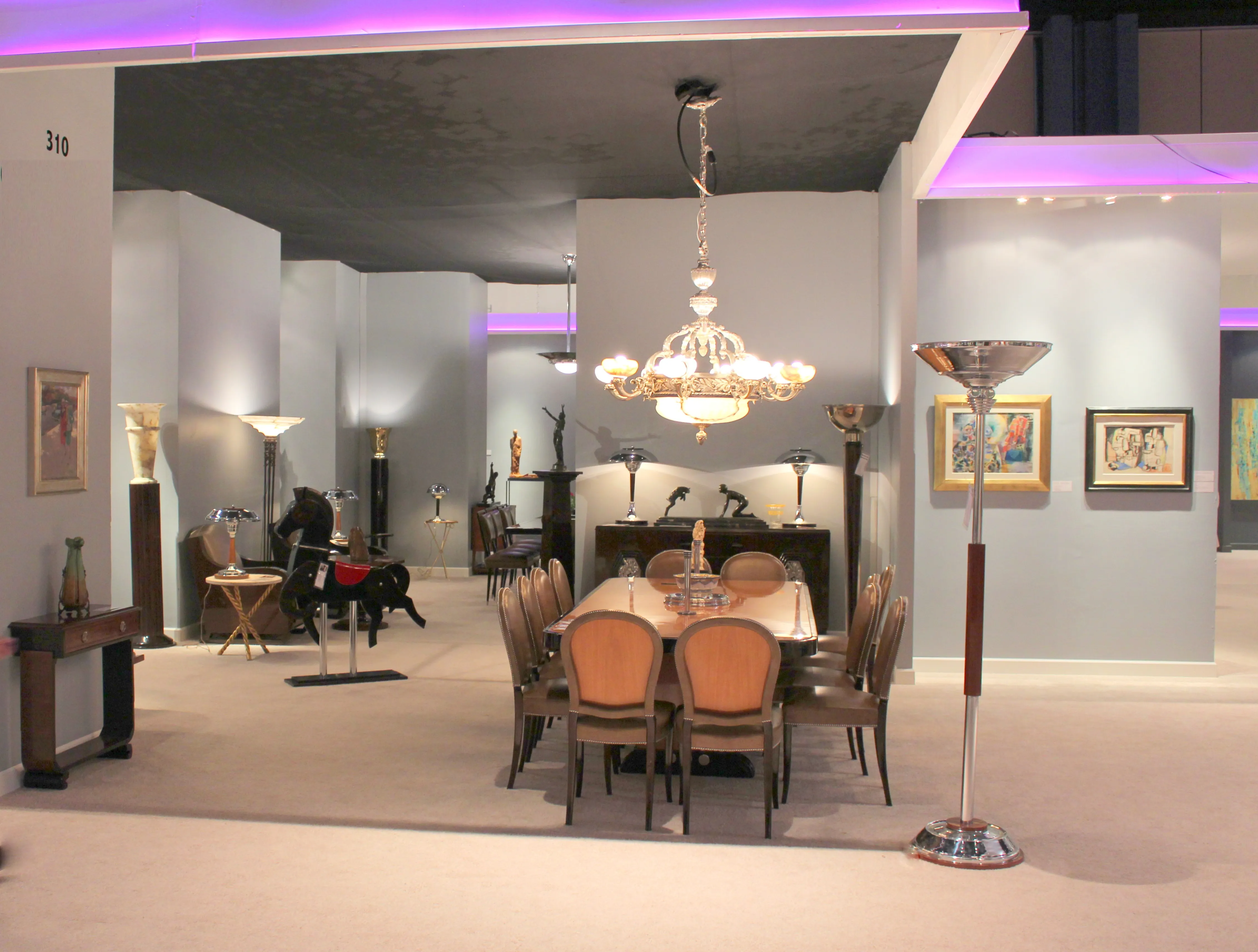 Salle d'exposition avec des antiquités à Miami, y compris des meubles élégants et de l'art.
