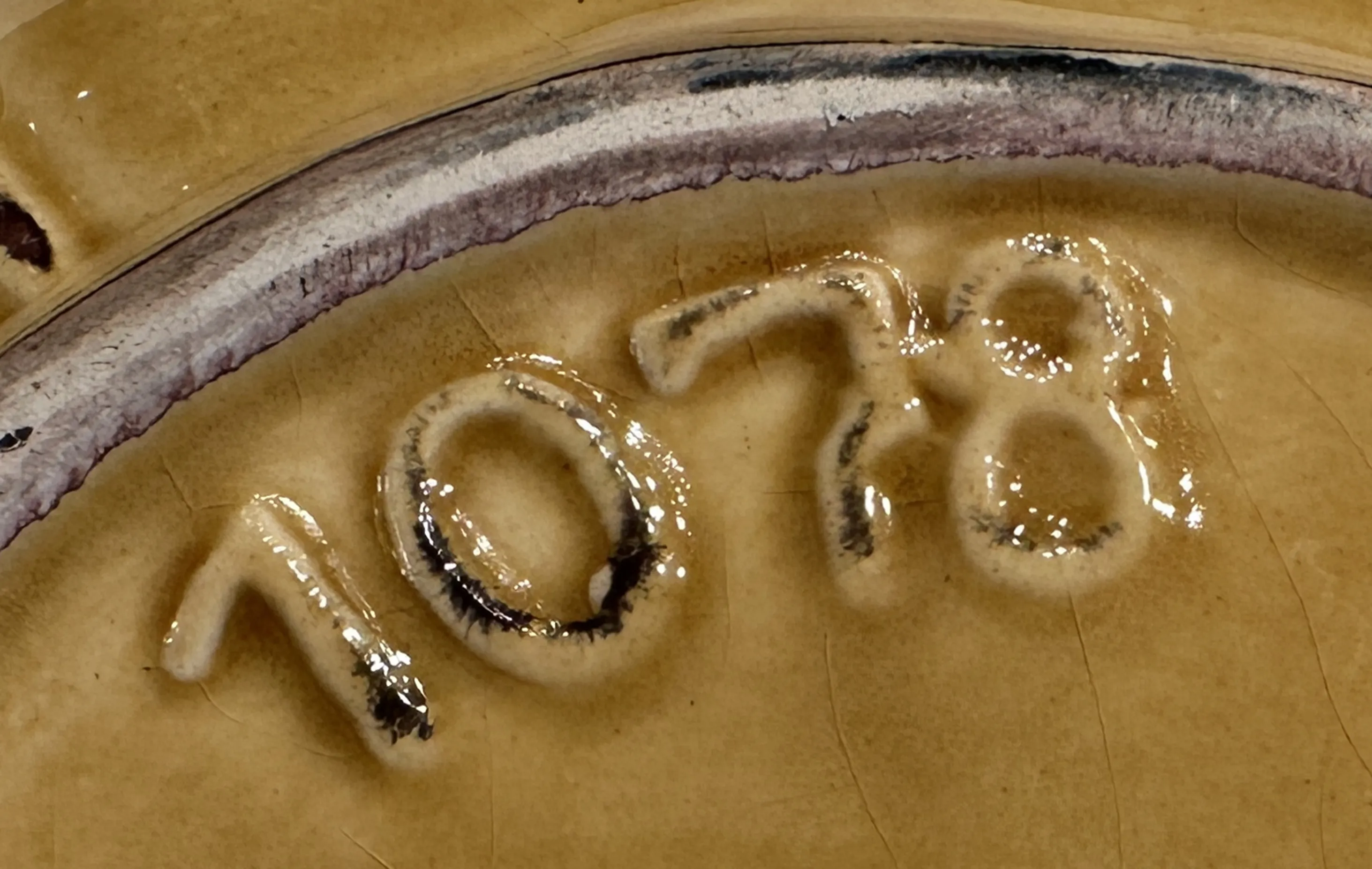 detail of serial number 1078 on an antique object, shiny surface and smooth texture.