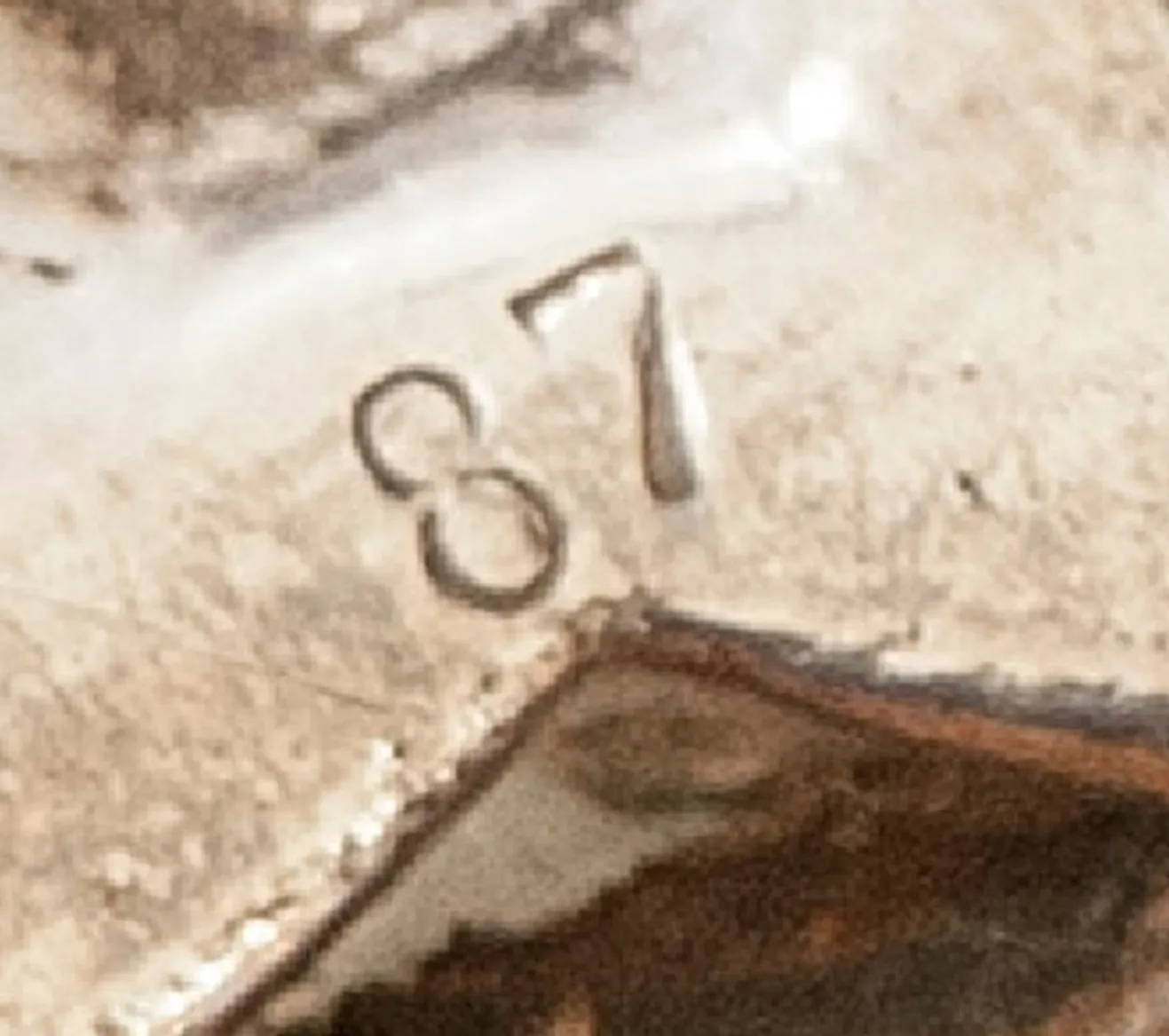 Close-up of an antique showing the serial number 87.