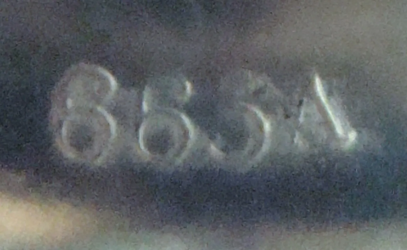 antique inscription with serial number 665 A against a blurred background