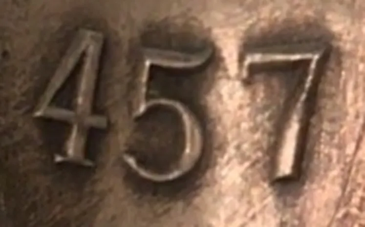 détails d'un numéro de série 457, texture visible, partie d'une antiquité