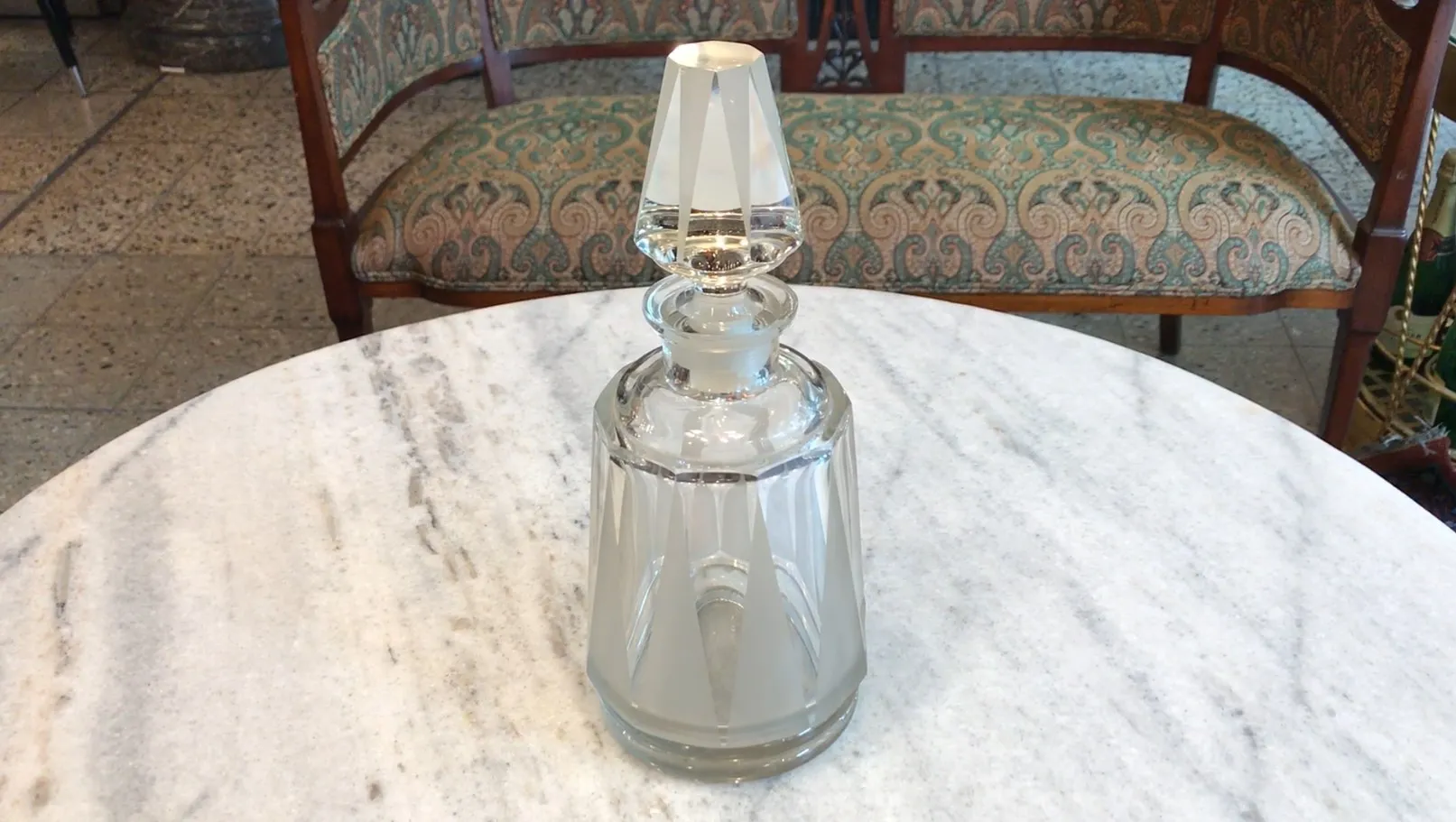 antique bottle with decorative lid on a table