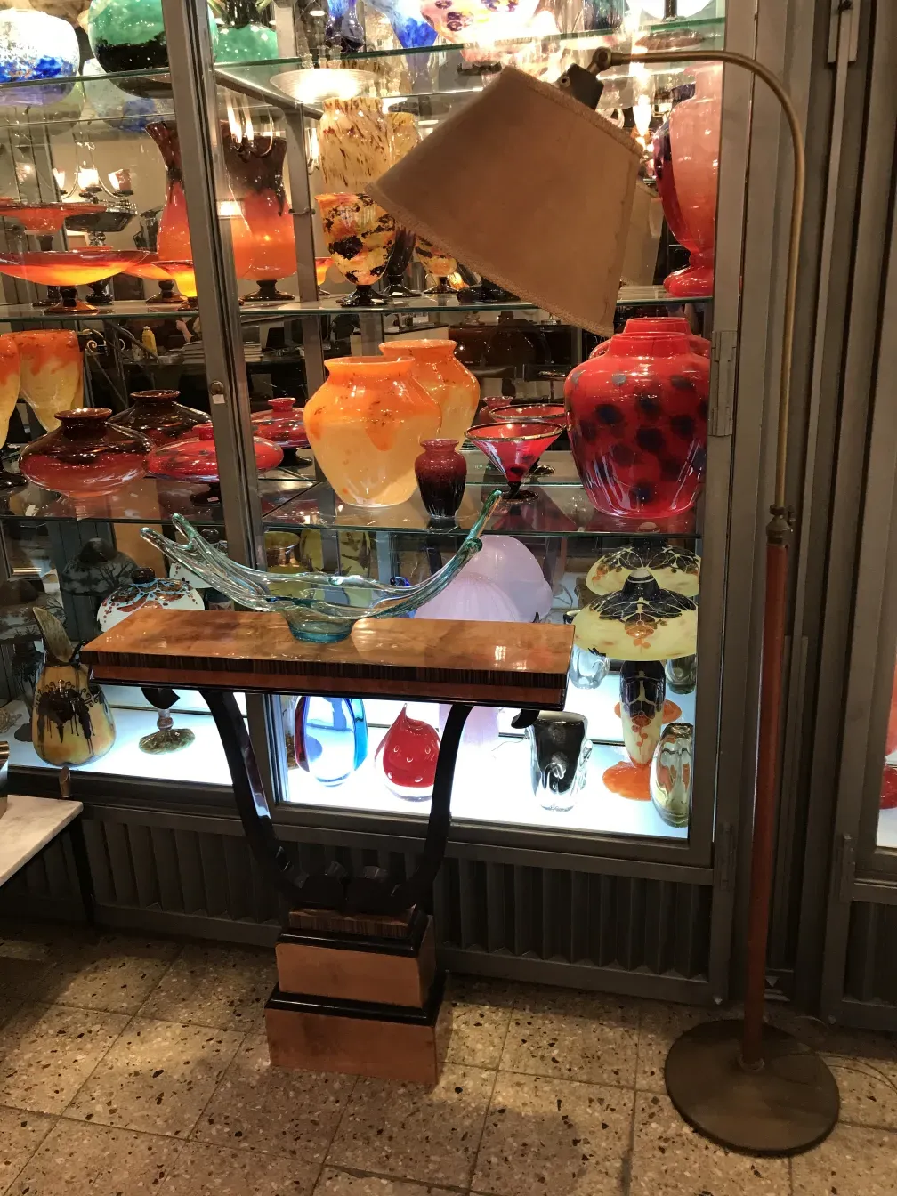 带透明灯罩的古董落地灯，周围是色彩鲜艳的古董