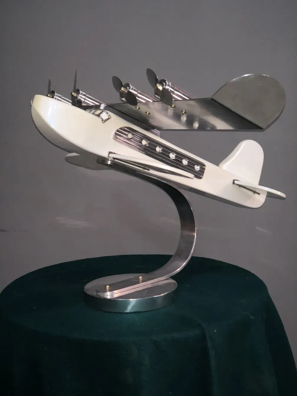 Antique aircraft model with metallic details, displayed on a stand.
