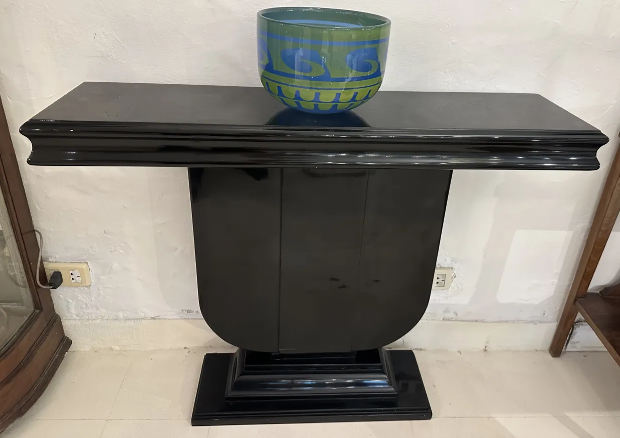 Dos consolas antiguas de diseño Art Deco, una con un jarrón decorativo encima.