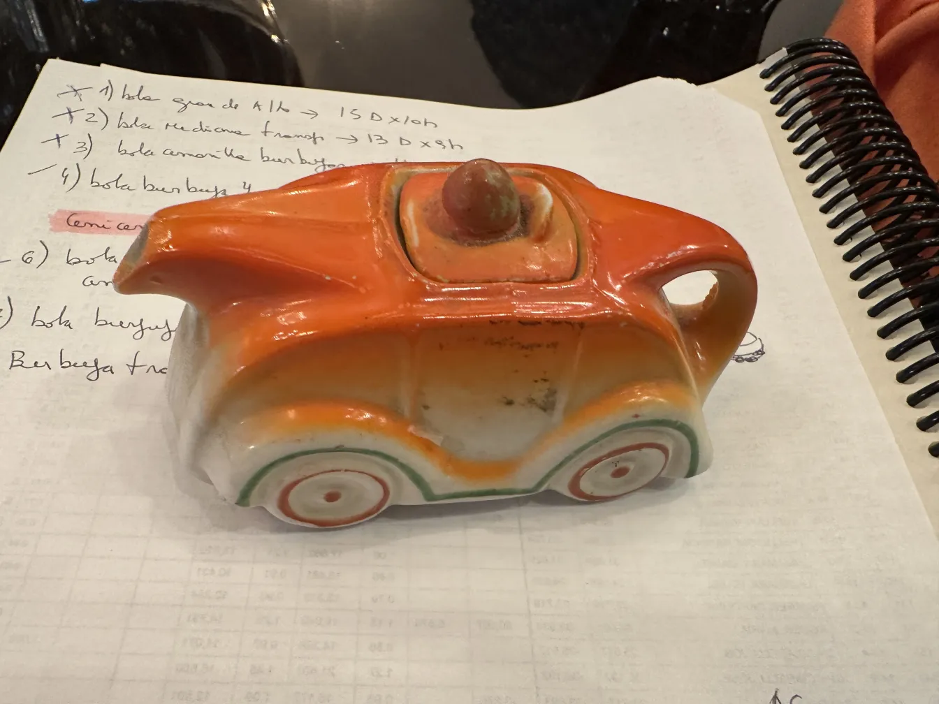 古い陶器の車の形、オレンジ色。