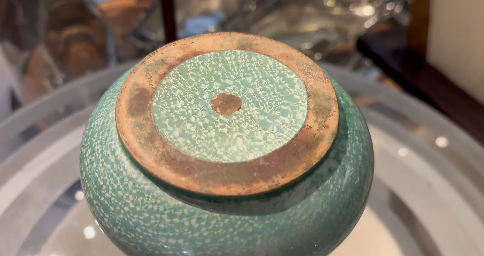 Vista inferiore di una ceramica antica Sarreguemines in verde con dettagli visivi.