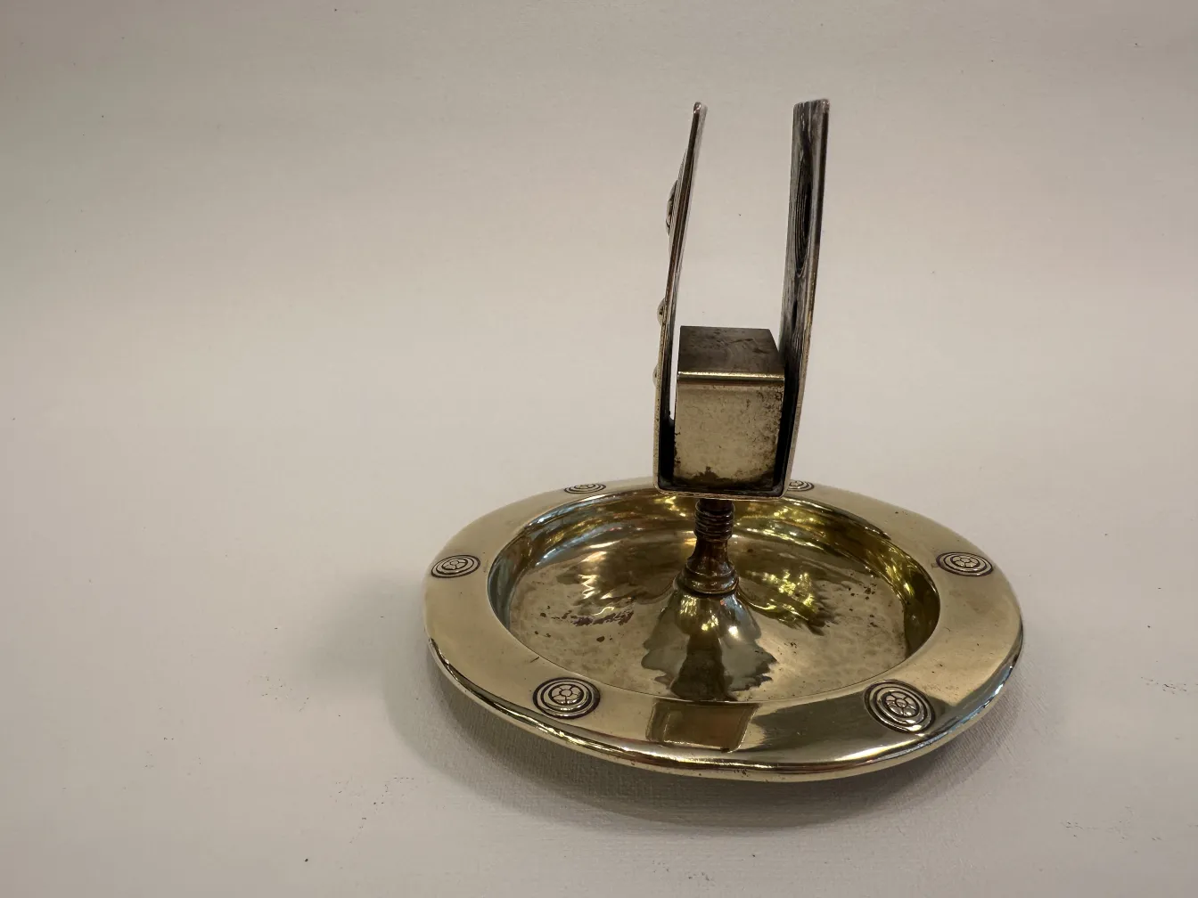 Antique WMF ashtray with decorative design and circular shape.