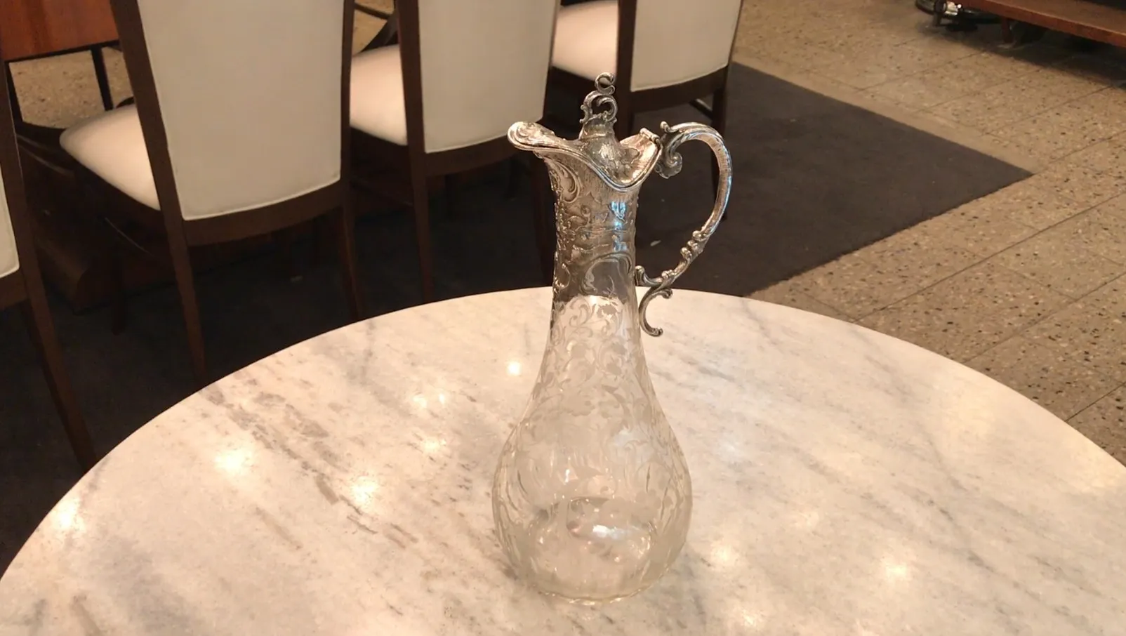 two antique WMF jars with intricate design and decorative handles, in an elegant setting