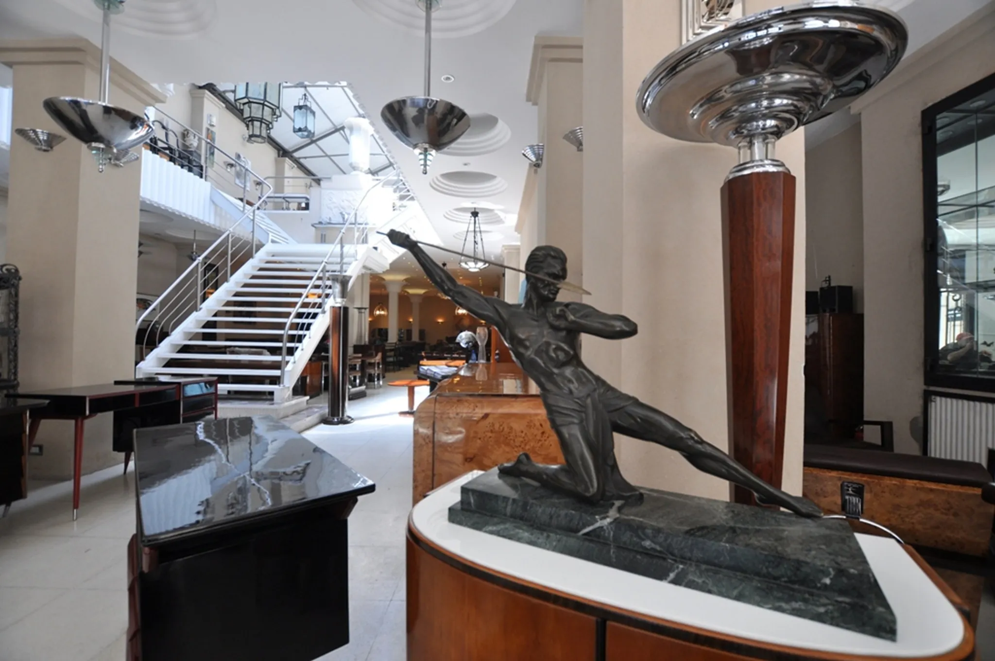 Dos lámparas de pie antiguas en un elegante ambiente con escaleras.