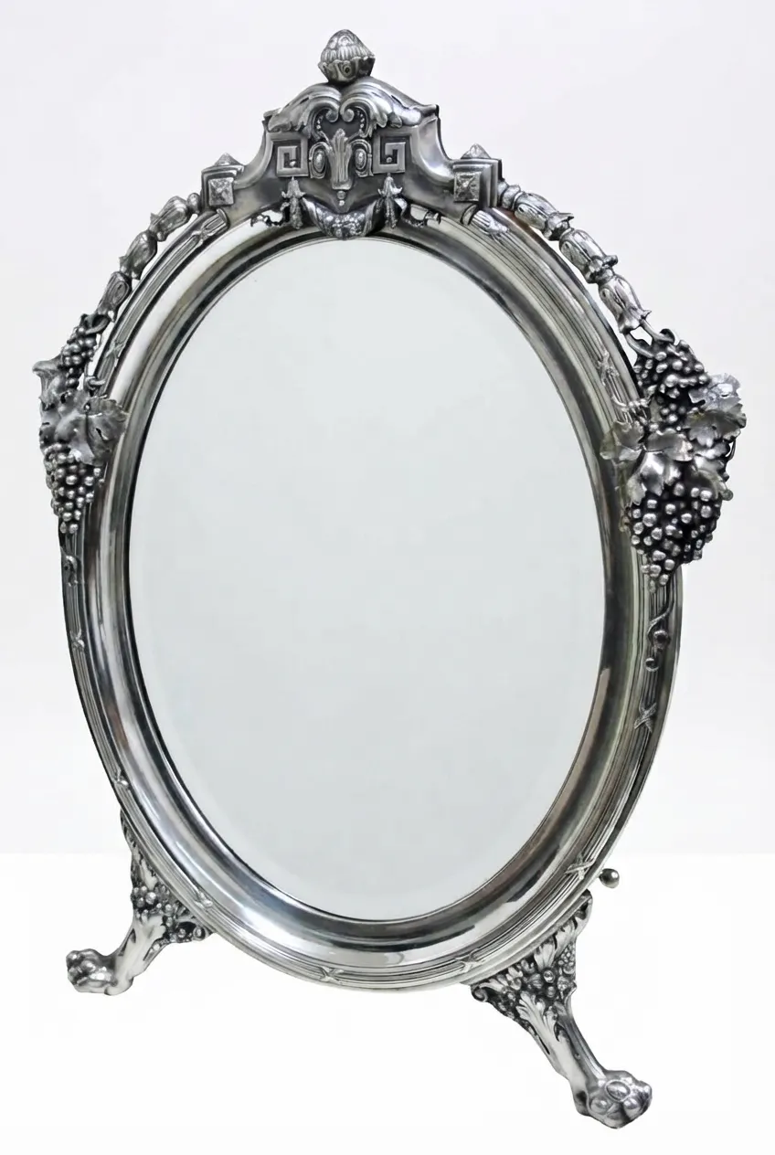 Antique mirror with ornate frame and stand.
