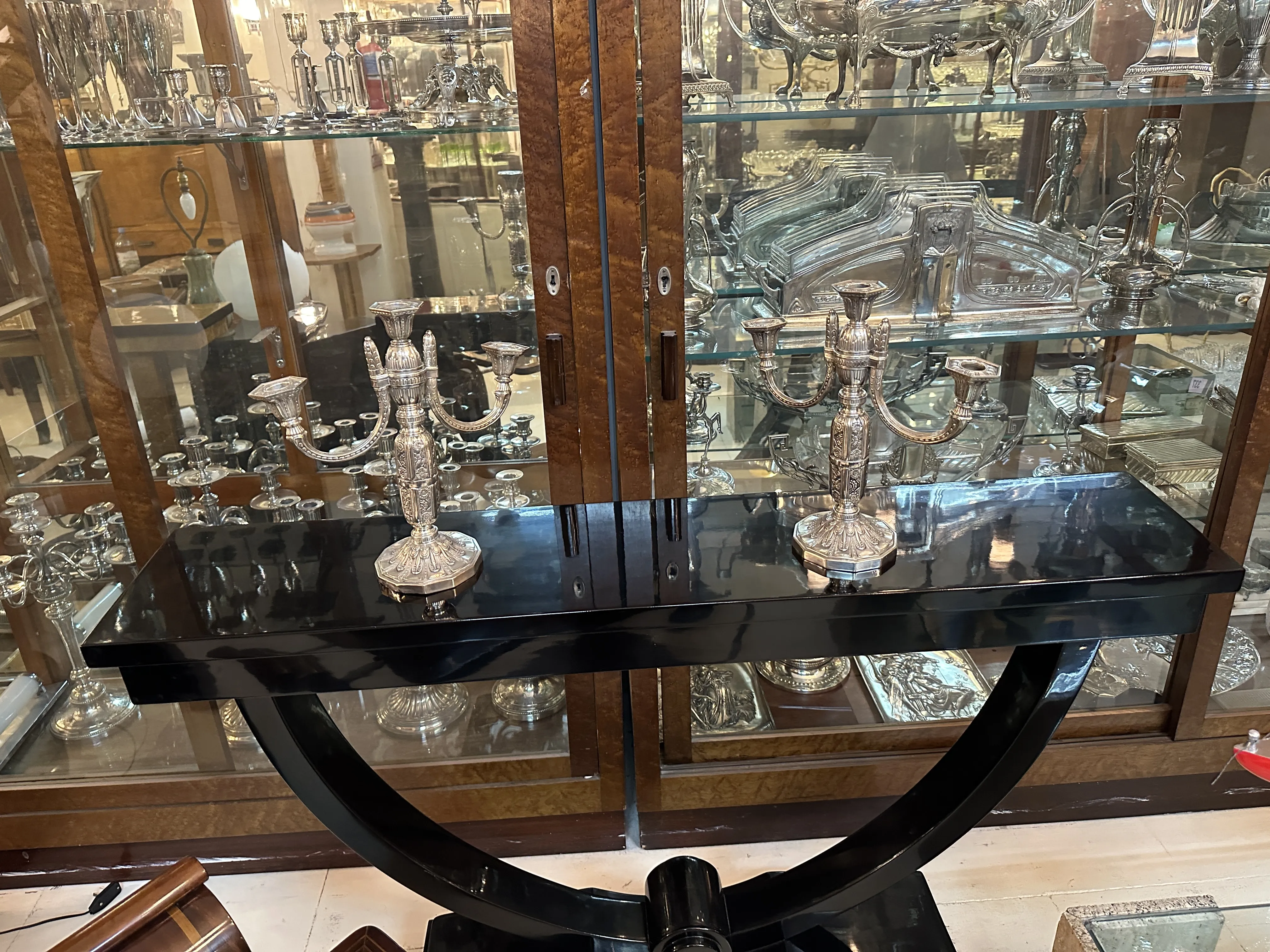 Two antique candlesticks on black table, elegant details.