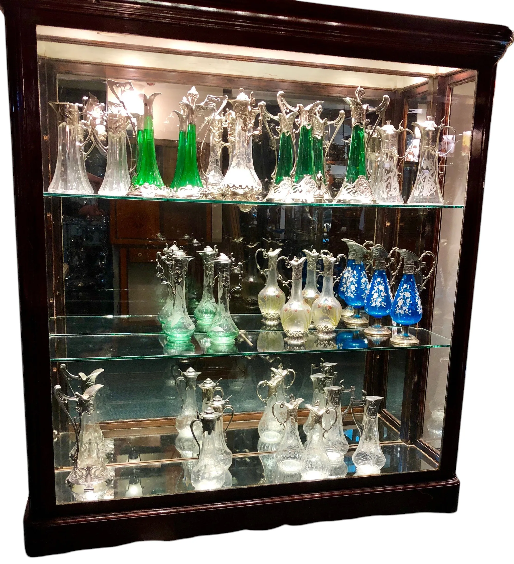 Display of 2 antique WMF jars in glass case, showcasing various colors and elegant shapes in an antique setting
