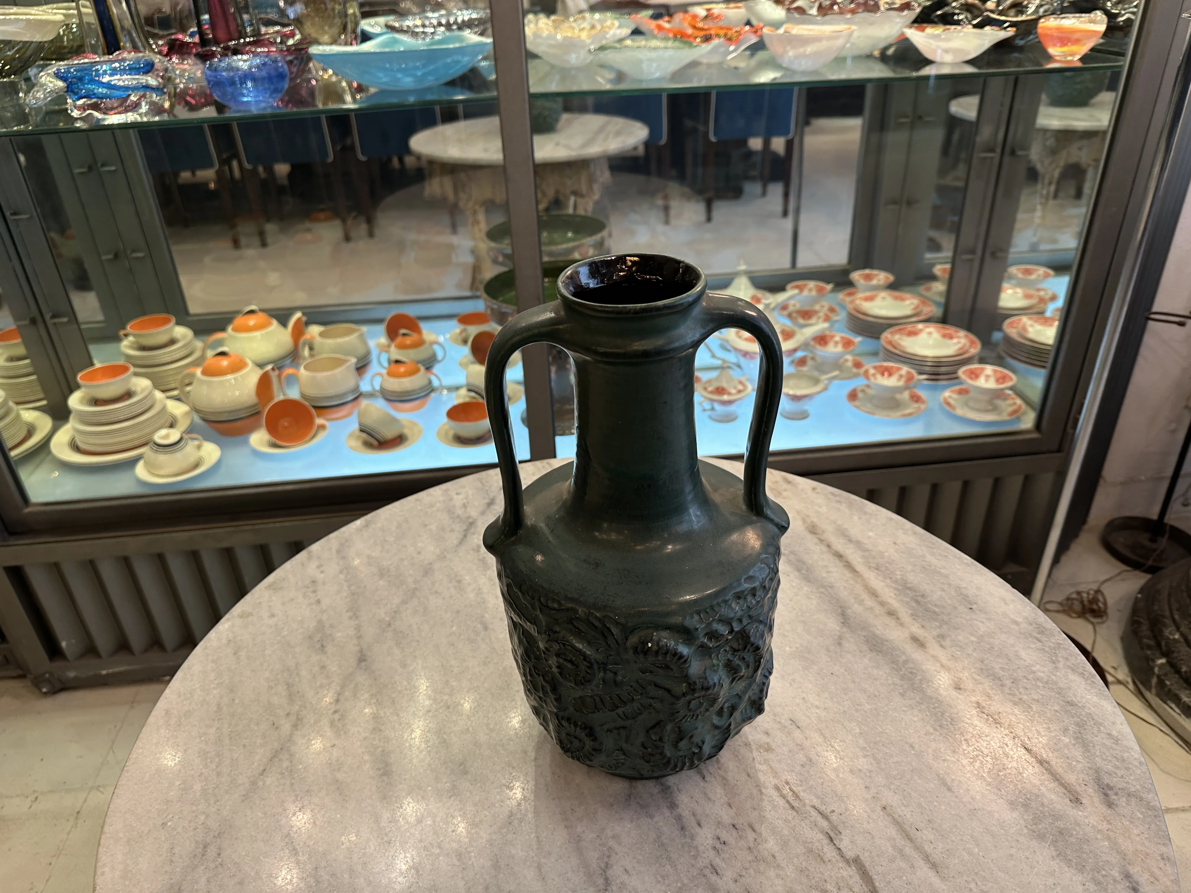 Vaso in ceramica antica con design elaborato, sfondo di stoviglie.