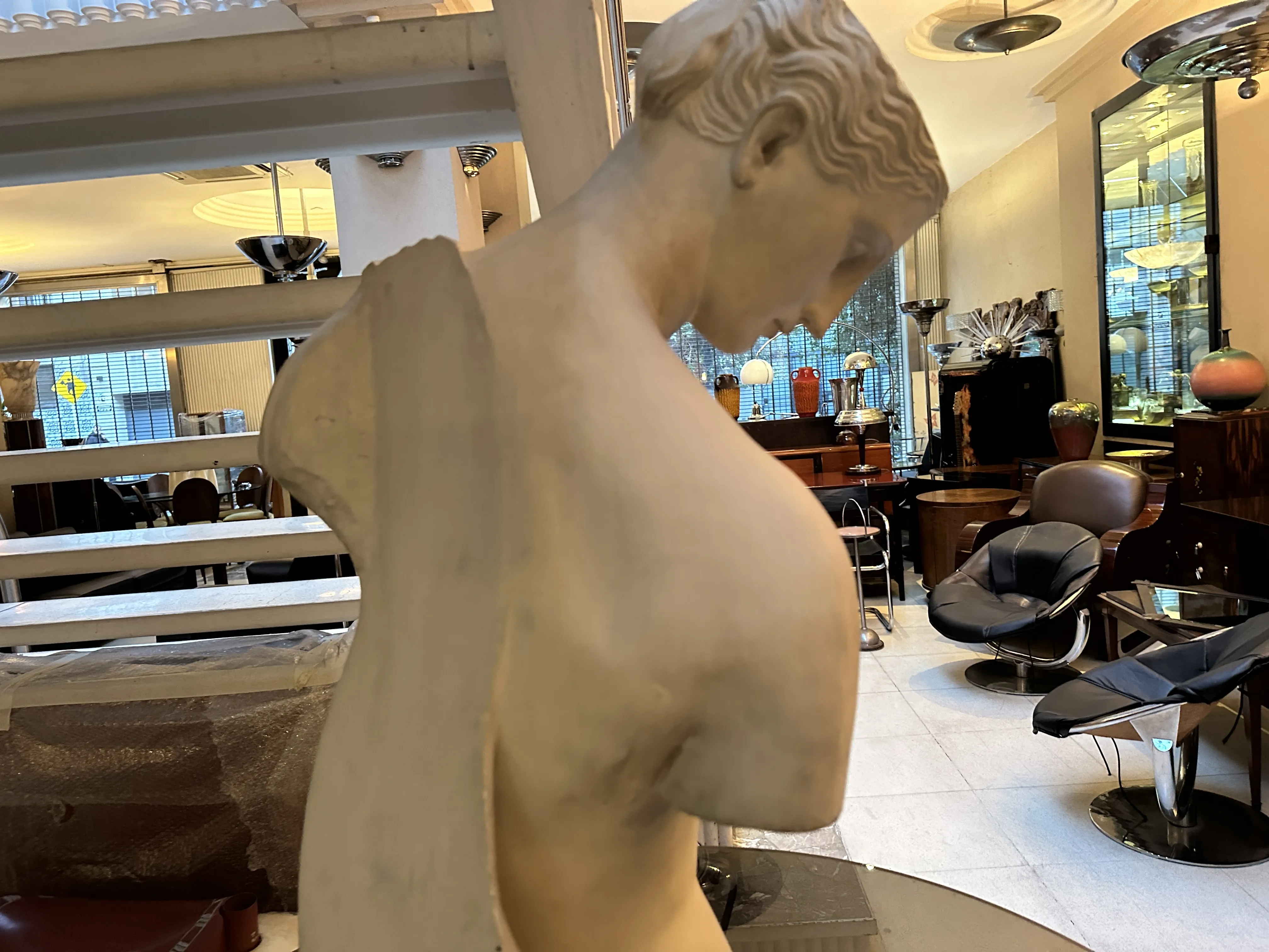 Escultura antiga mostrando um retrato, figuras em um ambiente elegante.