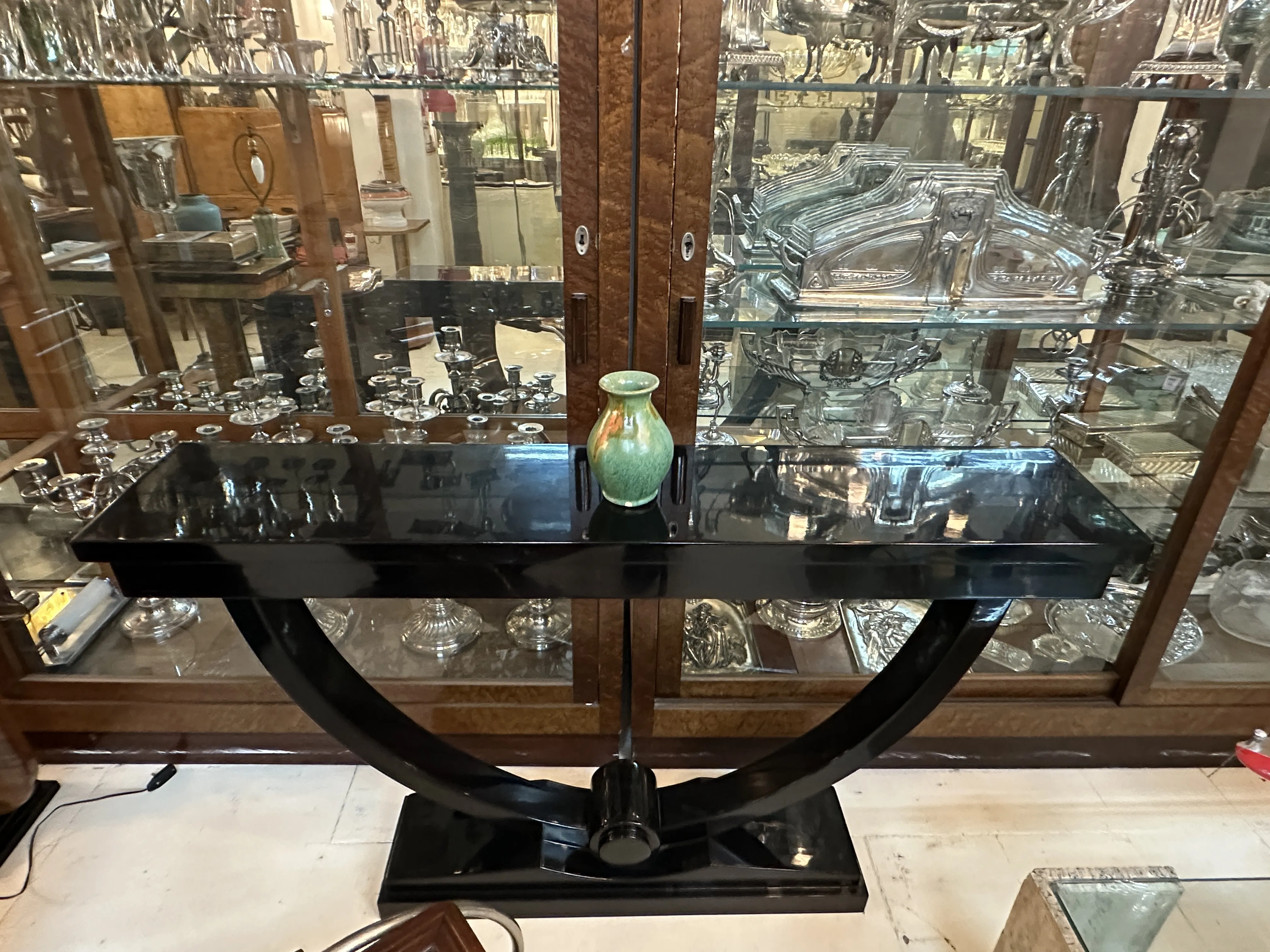 Vaso decorativo in ceramica antica su tavolo nero, sfondo con esposizione in vetro.