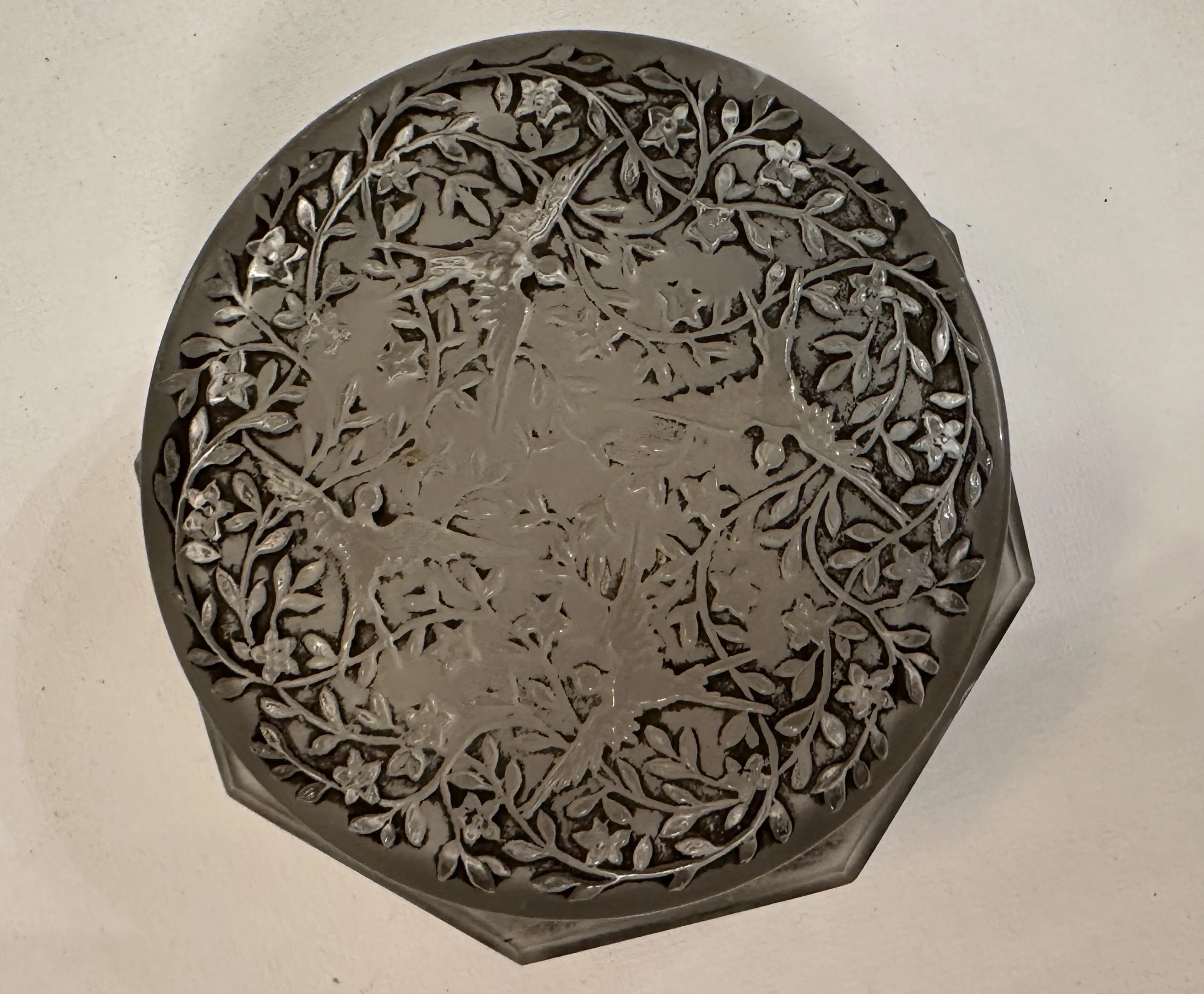 Boîte ancienne avec des motifs floraux intriqués sur le couvercle.