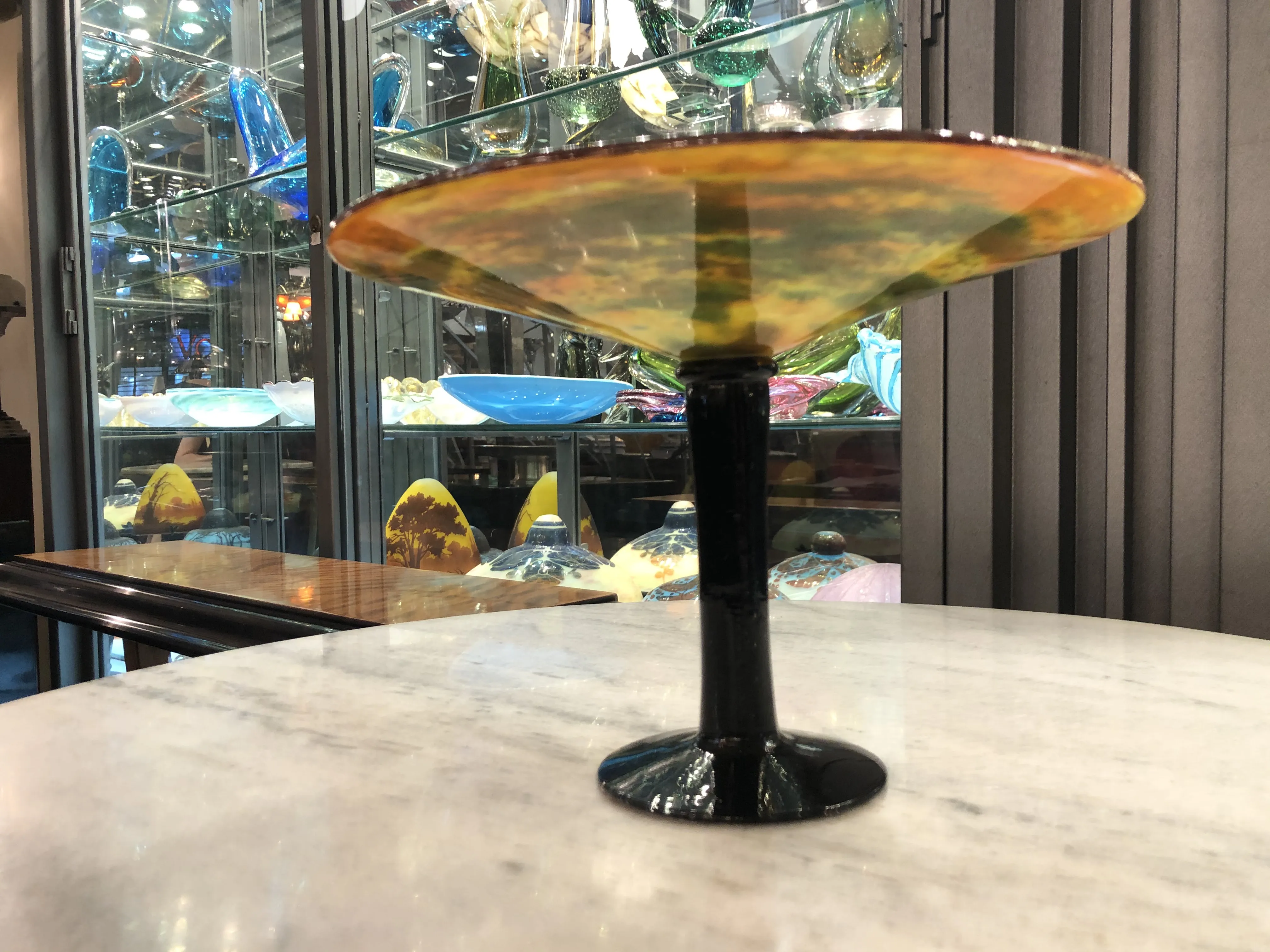 Side view of an antique signed glass Schneider french on a table