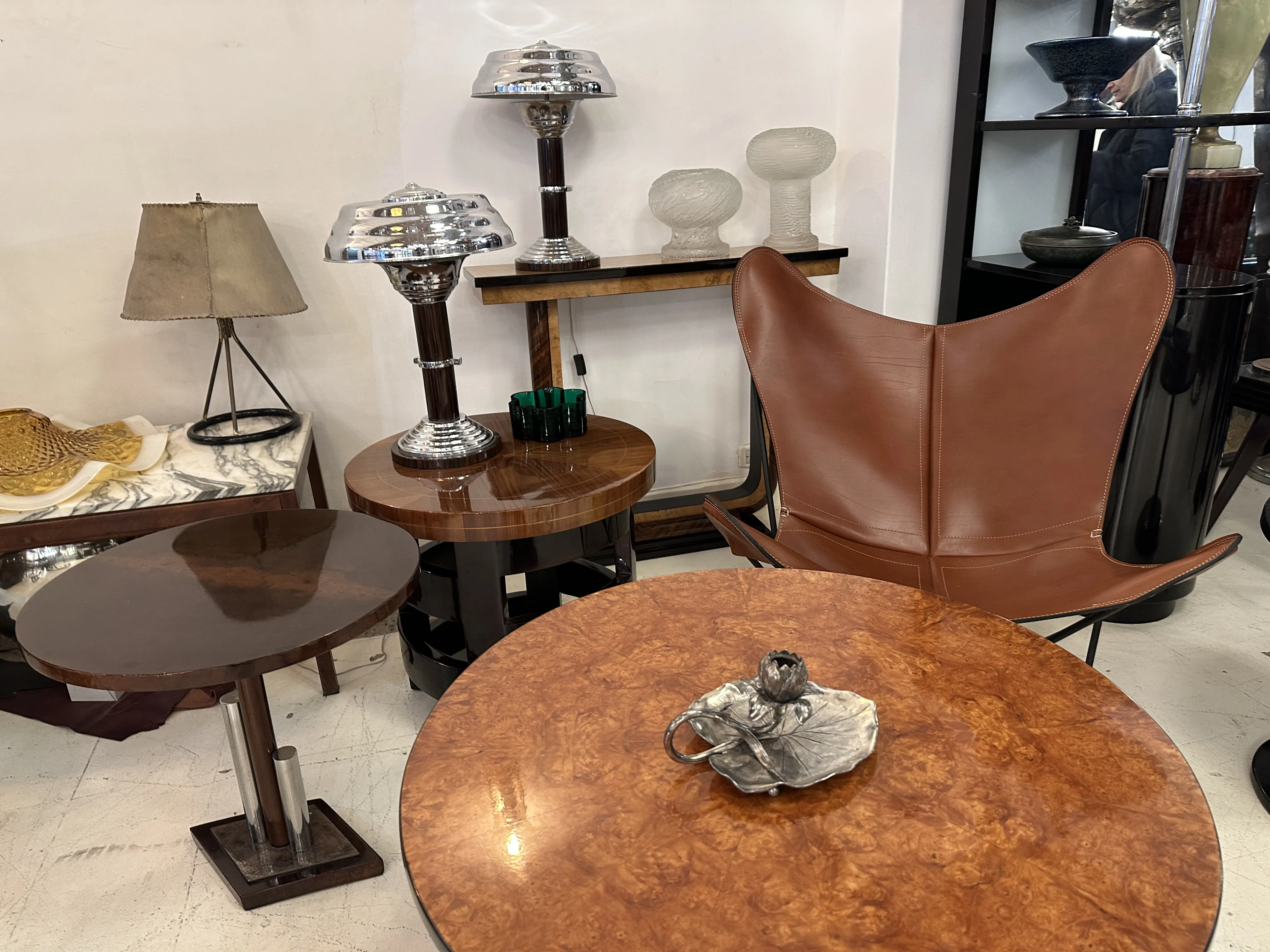 Antique candelabra among various antiques, including tables and lamps.