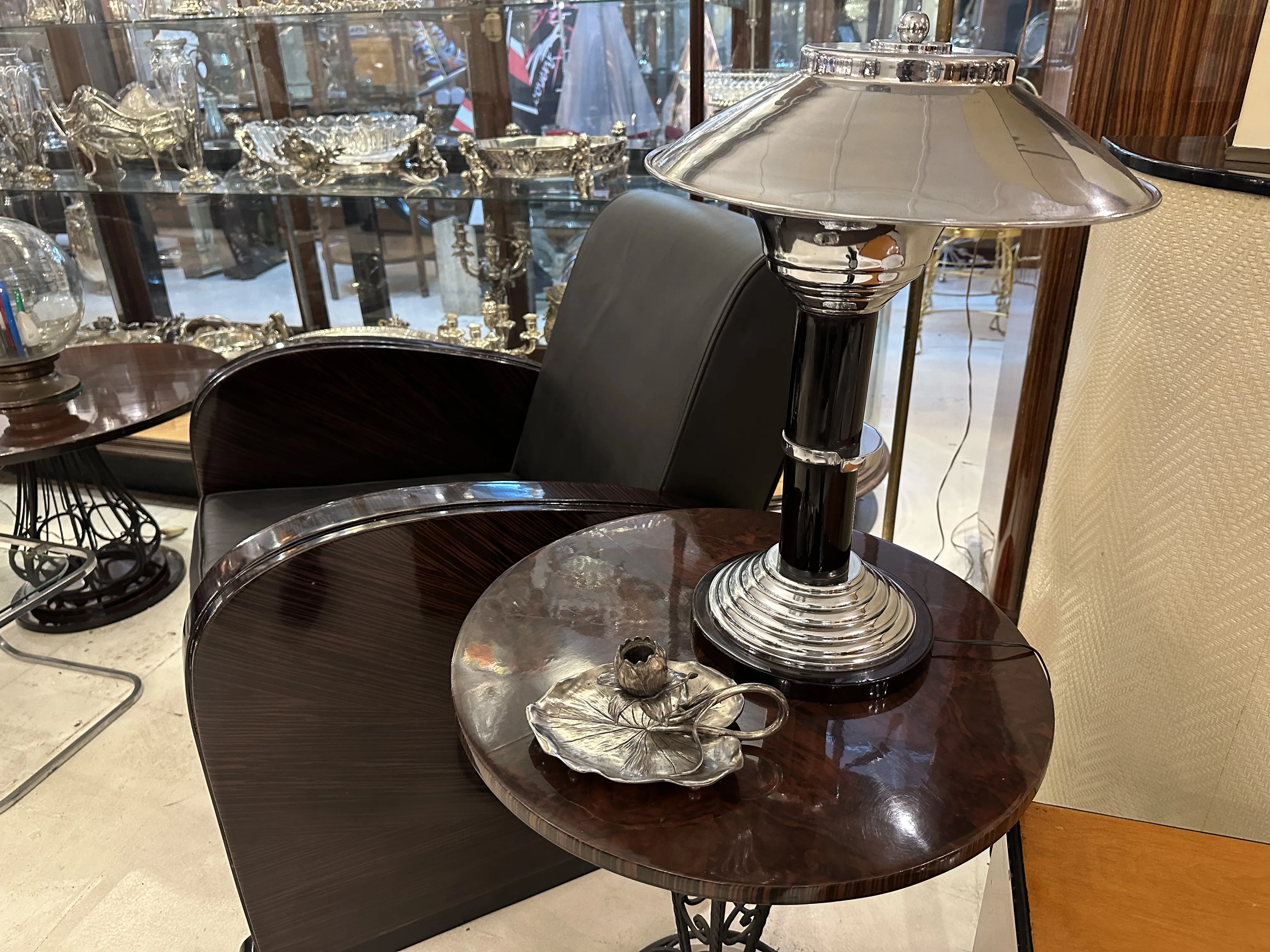 Antique candelabra on a table beside a black chair