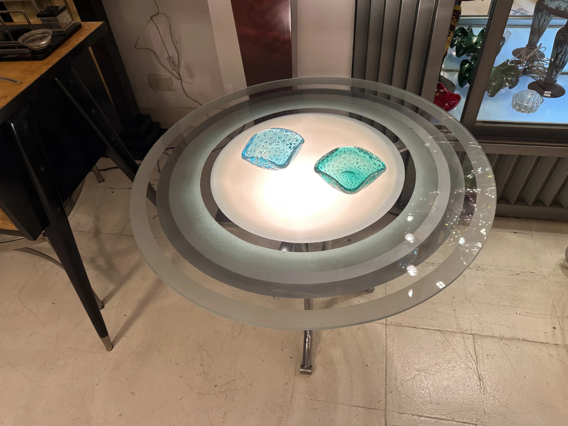Circular table with antique upholstery and soft decorative details.
