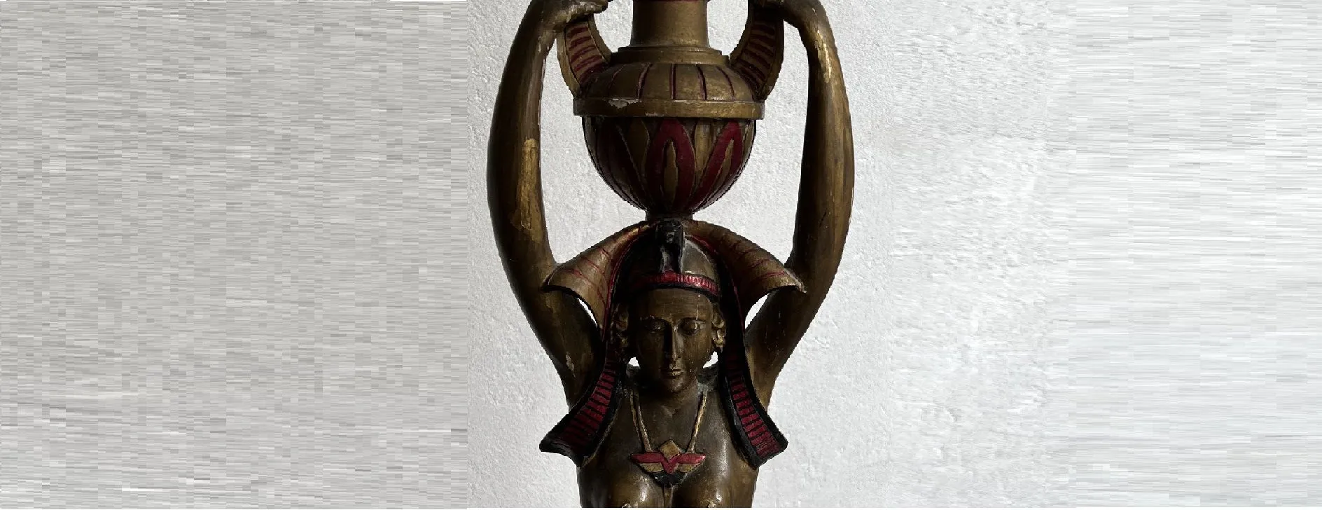 Escultura antiga de beleza com uma figura feminina segurando um vaso decorativo.