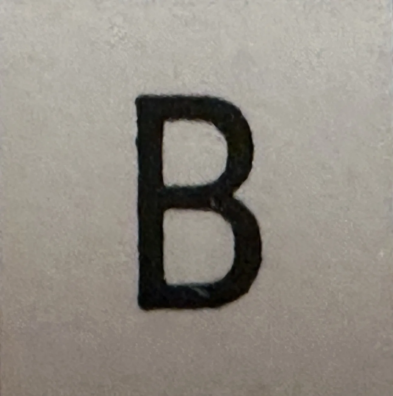 Detail eines alten Siegels mit dem Buchstaben B, klassisches Design.
