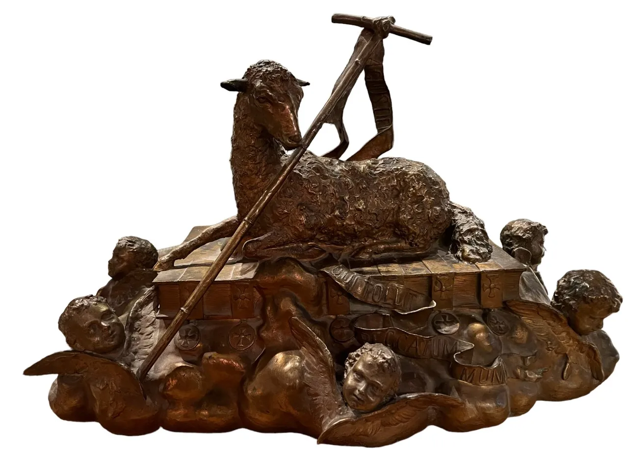 Antique sculpture of a lamb surrounded by angelic figures.