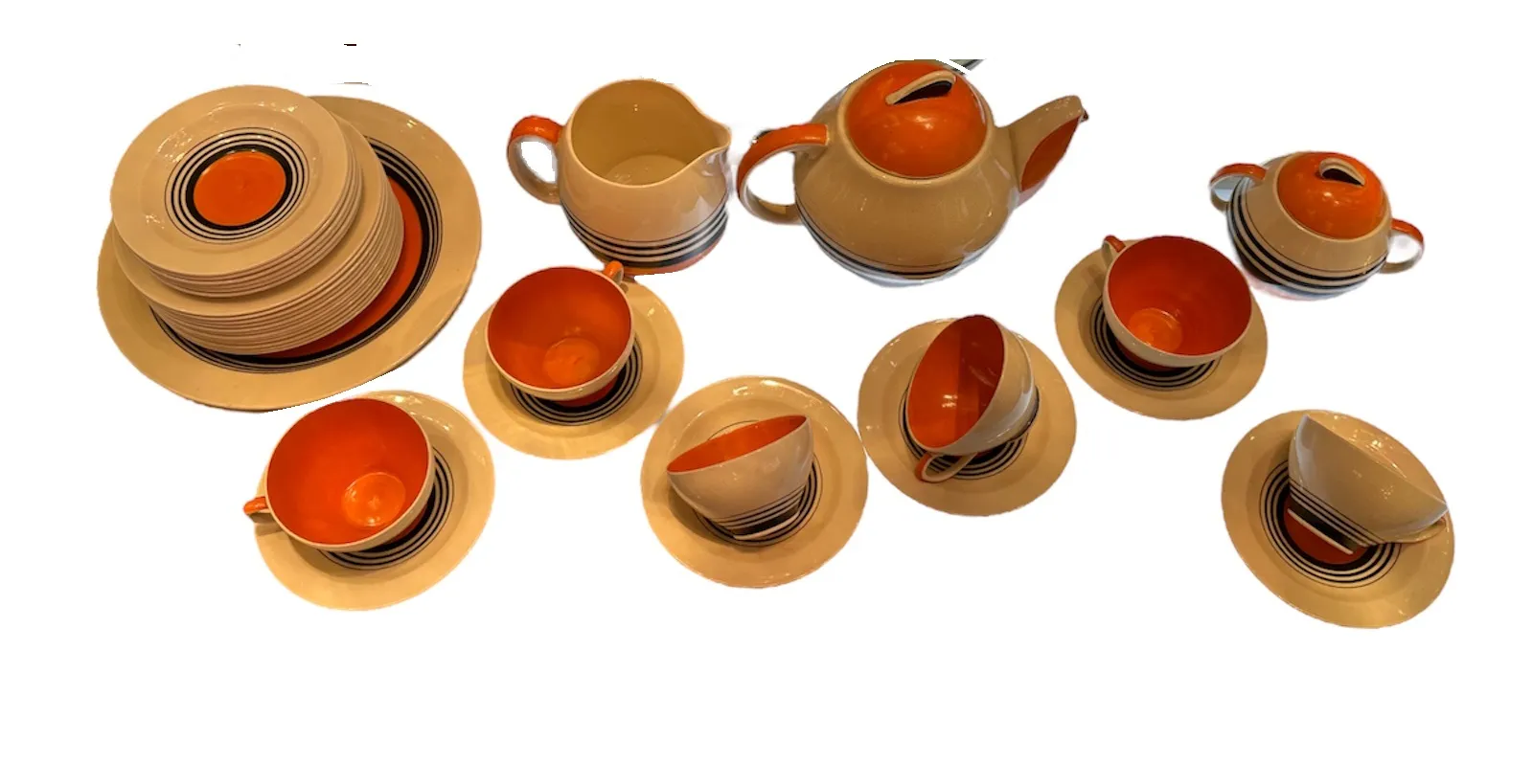 Vintage tea set with colorful patterns on cups, plates, and teapot arranged in various positions, creating a harmonious collection.