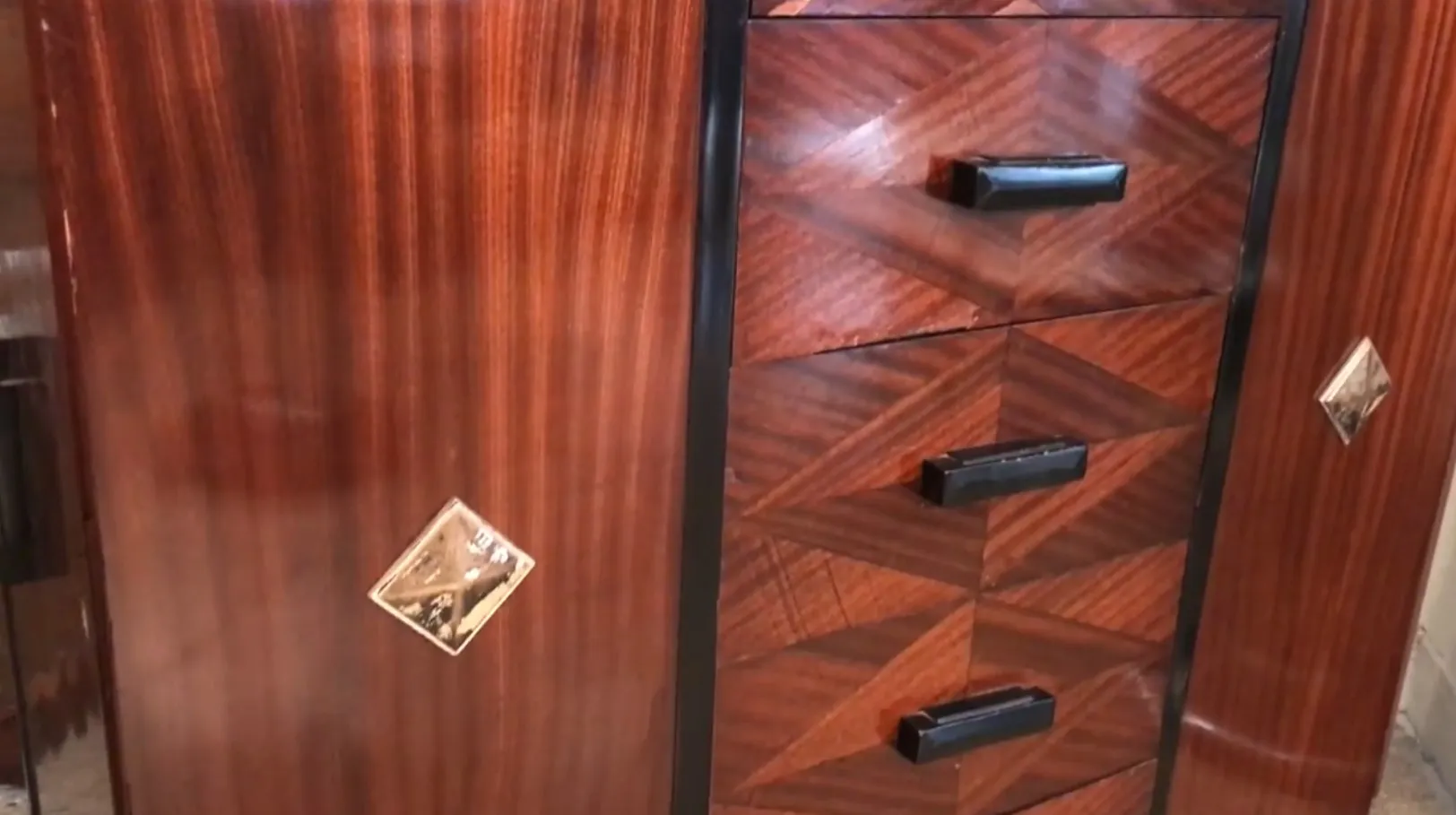 Antike Schublade mit geometrischem Design und schwarzen Griffen in klassischem Ambiente.