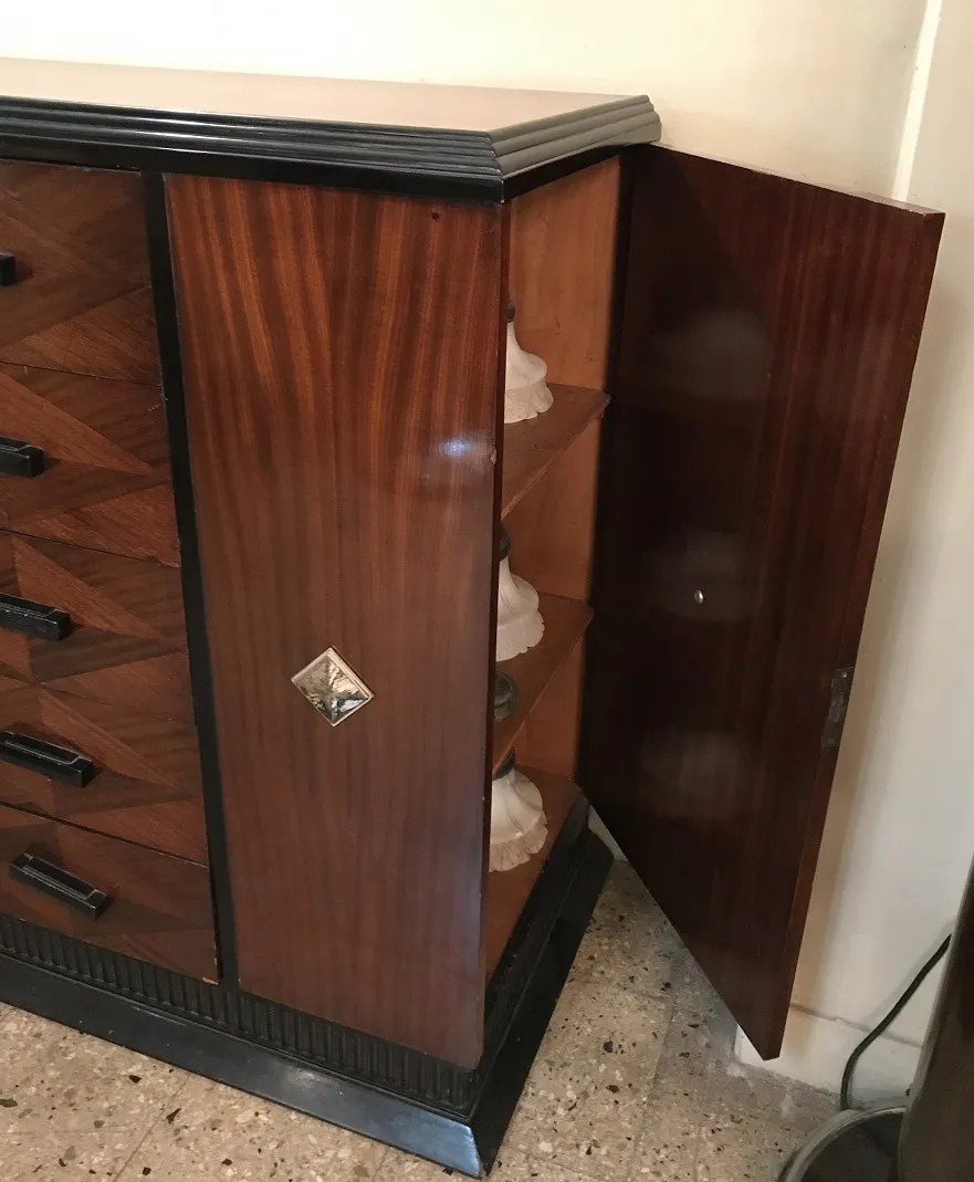 Gaveteira antiga com acabamentos em madeira e prateleiras internas, decorada.