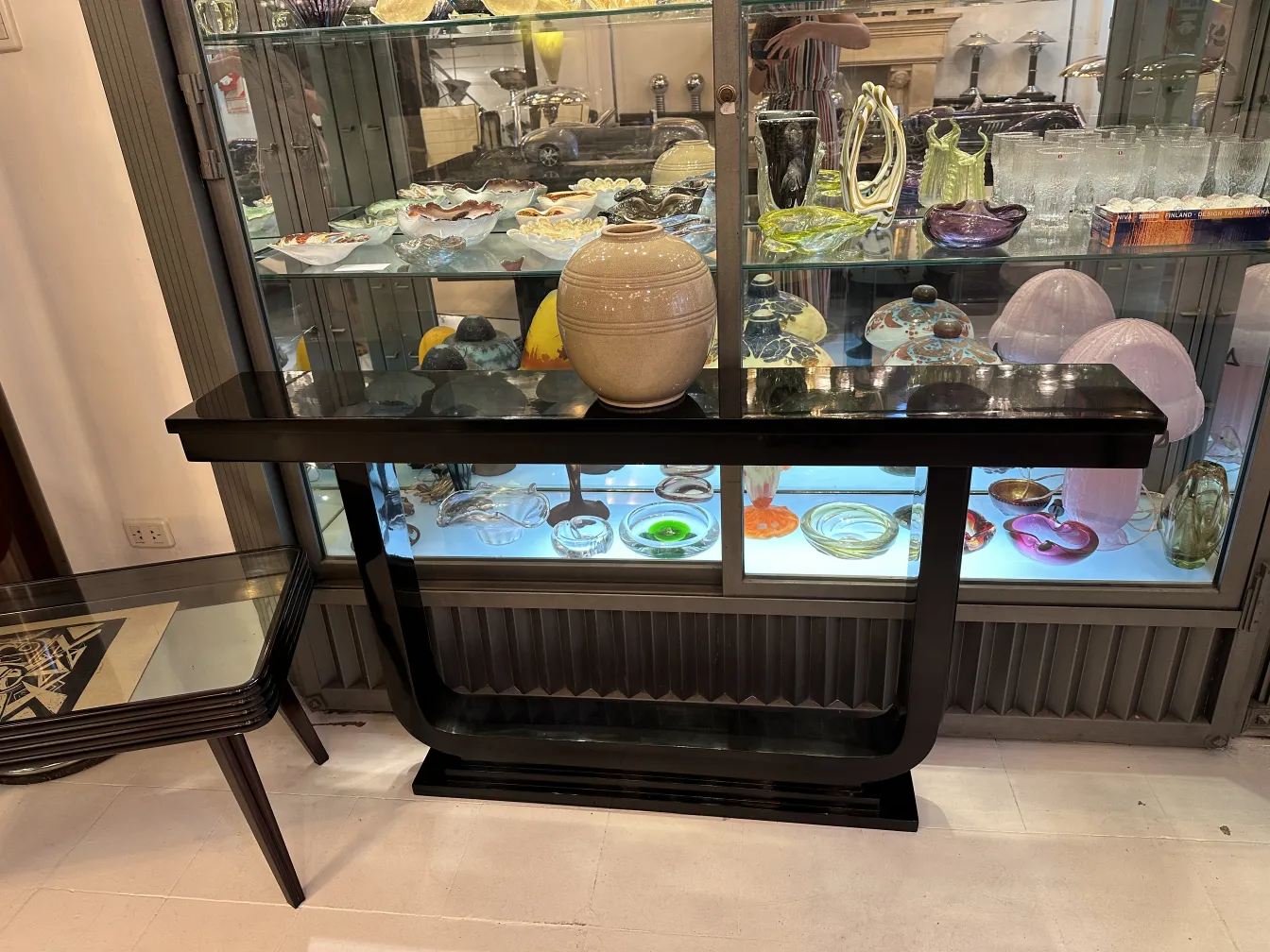 Vase en céramique ancienne décorative sur une table noire, ambiance élégante.