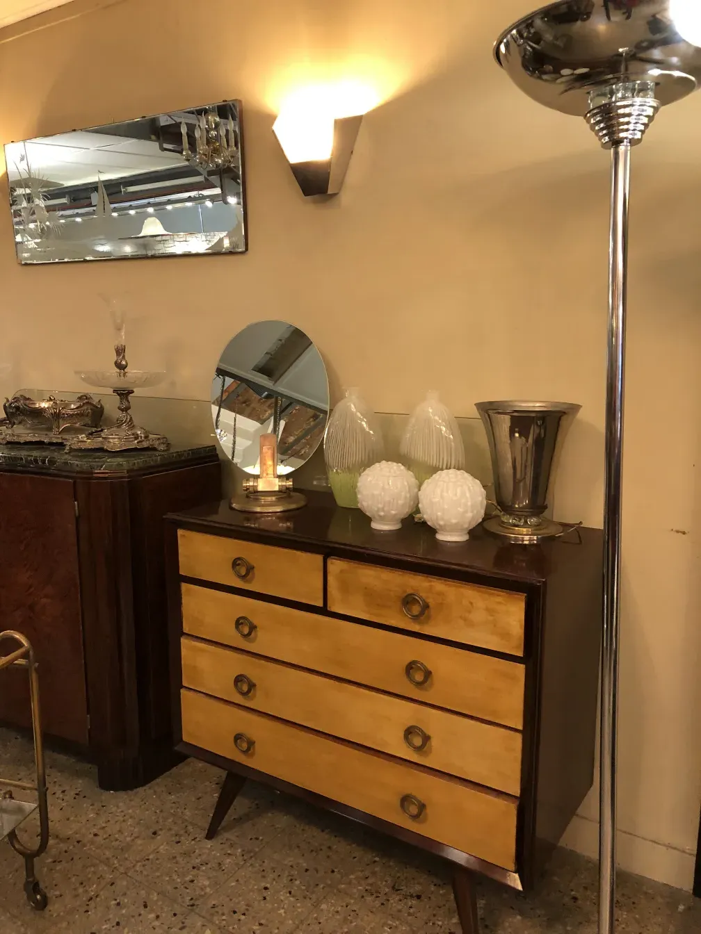 Commode ancienne aux tons clairs et foncés, avec poignées rondes dans un cadre élégant.