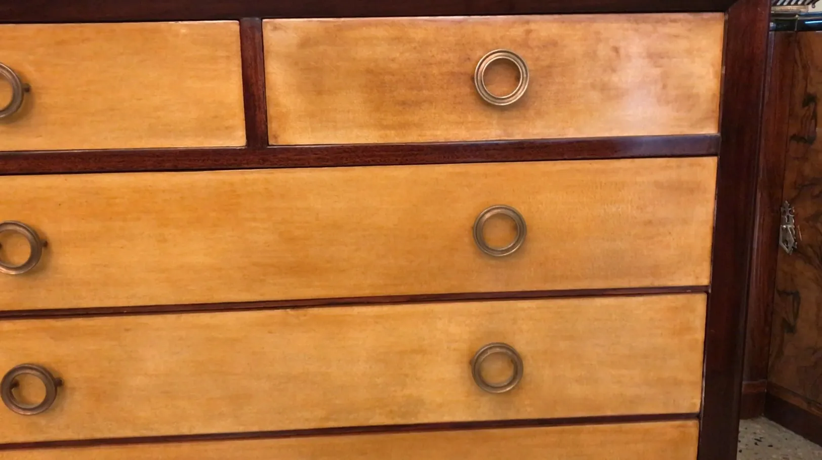 Comoda antigua con detalles en madera y tiradores de metal.