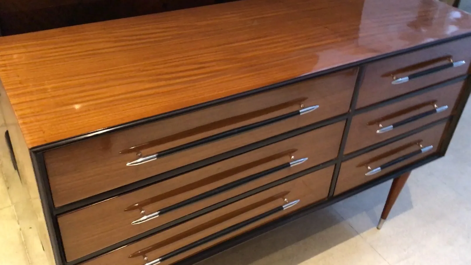 Antique cabinet with glossy finish and metal handles, four drawers