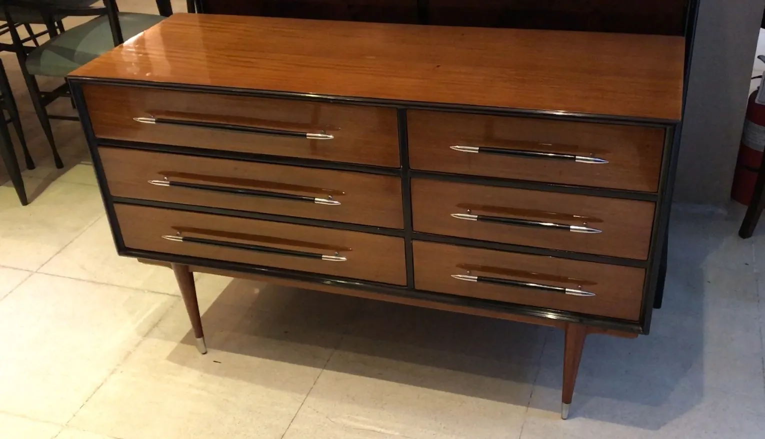 Commode antique avec six tiroirs et poignées en métal, sur fond clair