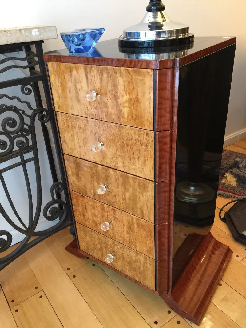 Cassetto antico in legno con quattro cassetti e manopole trasparenti.