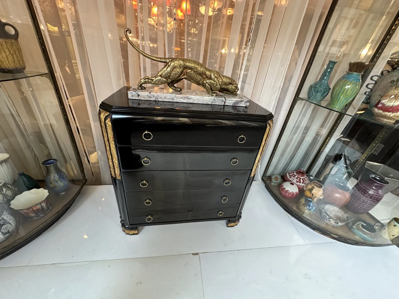 Schublade schwarz mit goldenen Details, geschmückt mit einer Pantherstatue.