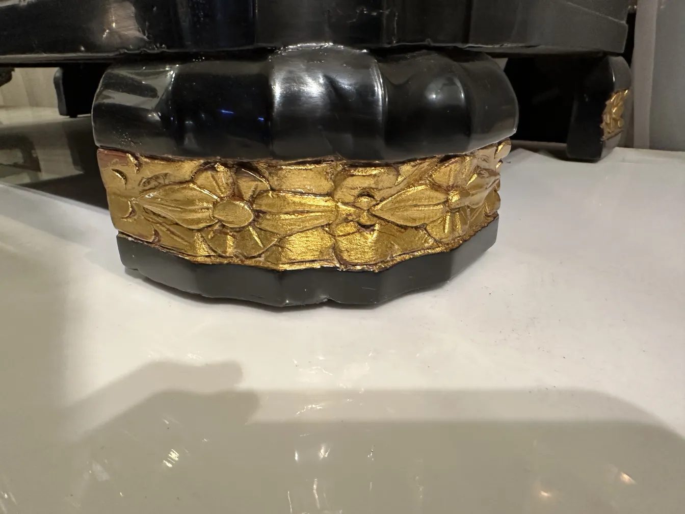 Cassetto antico con base dorata e dettagli decorativi su sfondo nero.