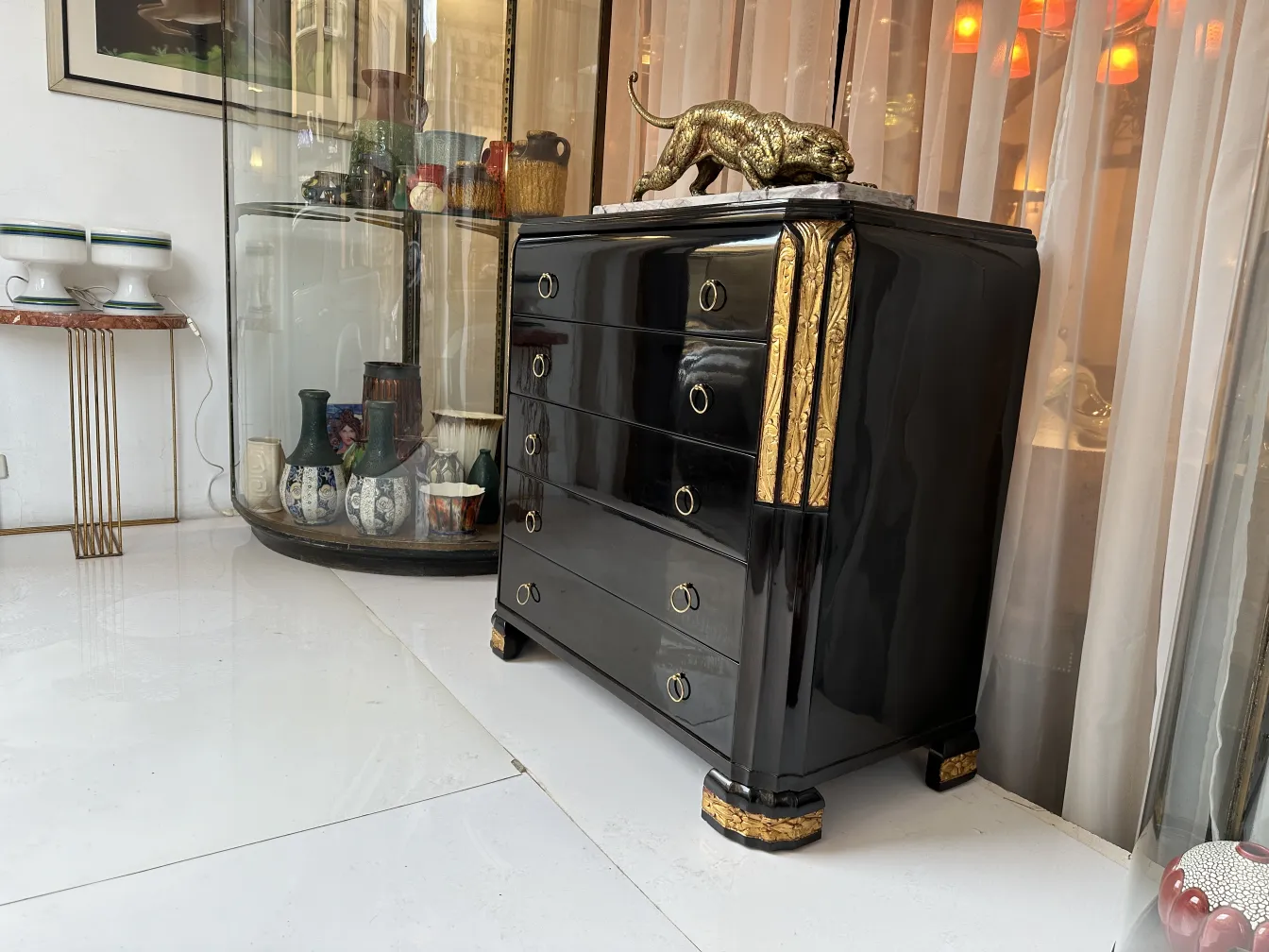 Cómoda antigua negra con dorado y decoración de león