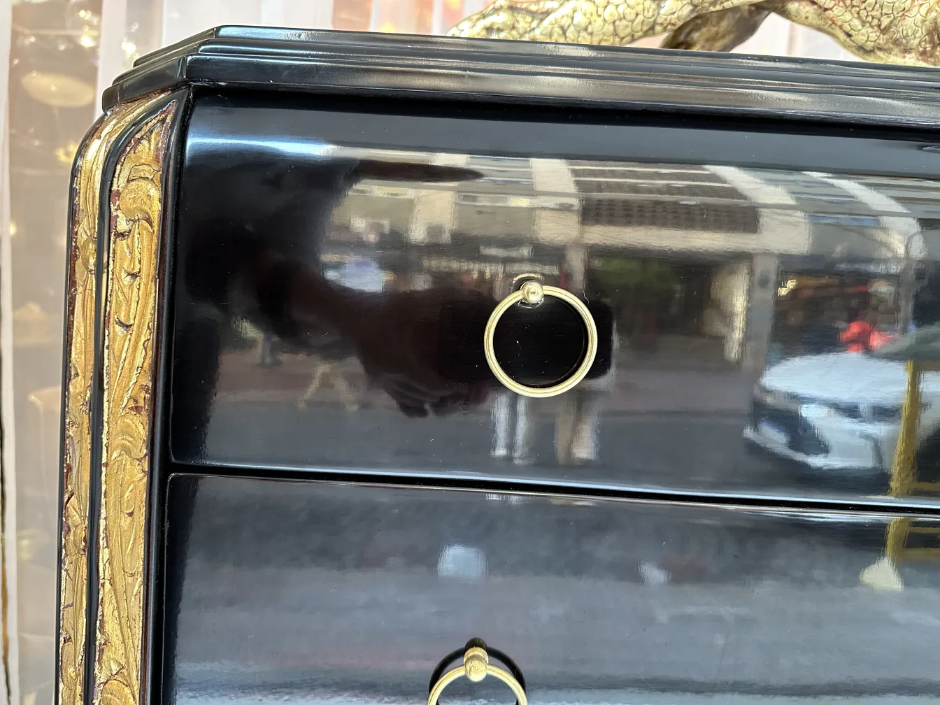 Antike Schublade mit schwarzem Finish und goldenen Akzenten.