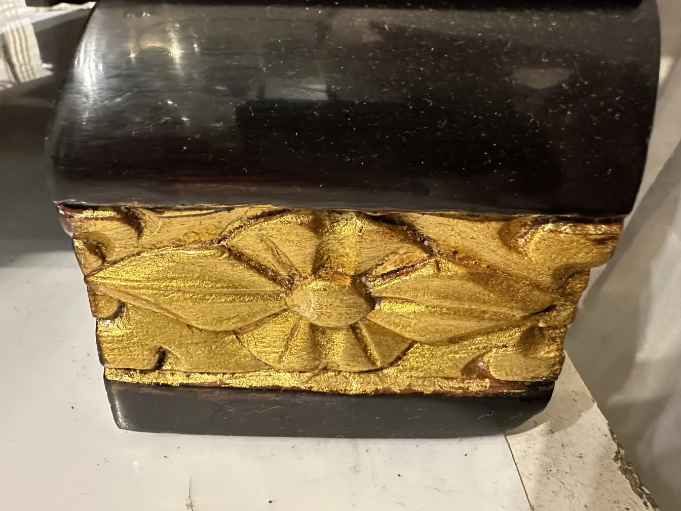 Comoda antigua con detalles dorados y un acabado elegante.