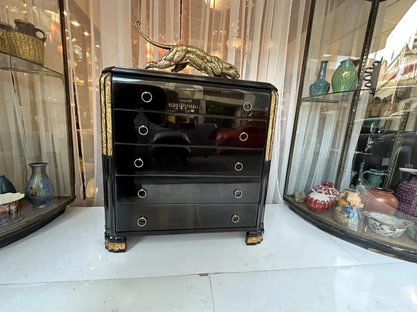 Cassettiera nera antica con dettagli dorati e felino decorativo