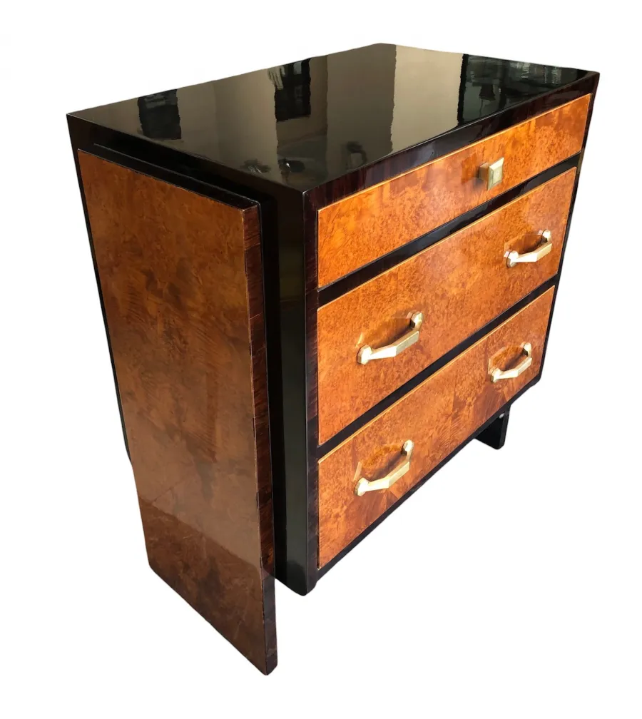 Cómoda antigua con dos puertas y tres cajones, marrón y negro, con tiradores dorados.