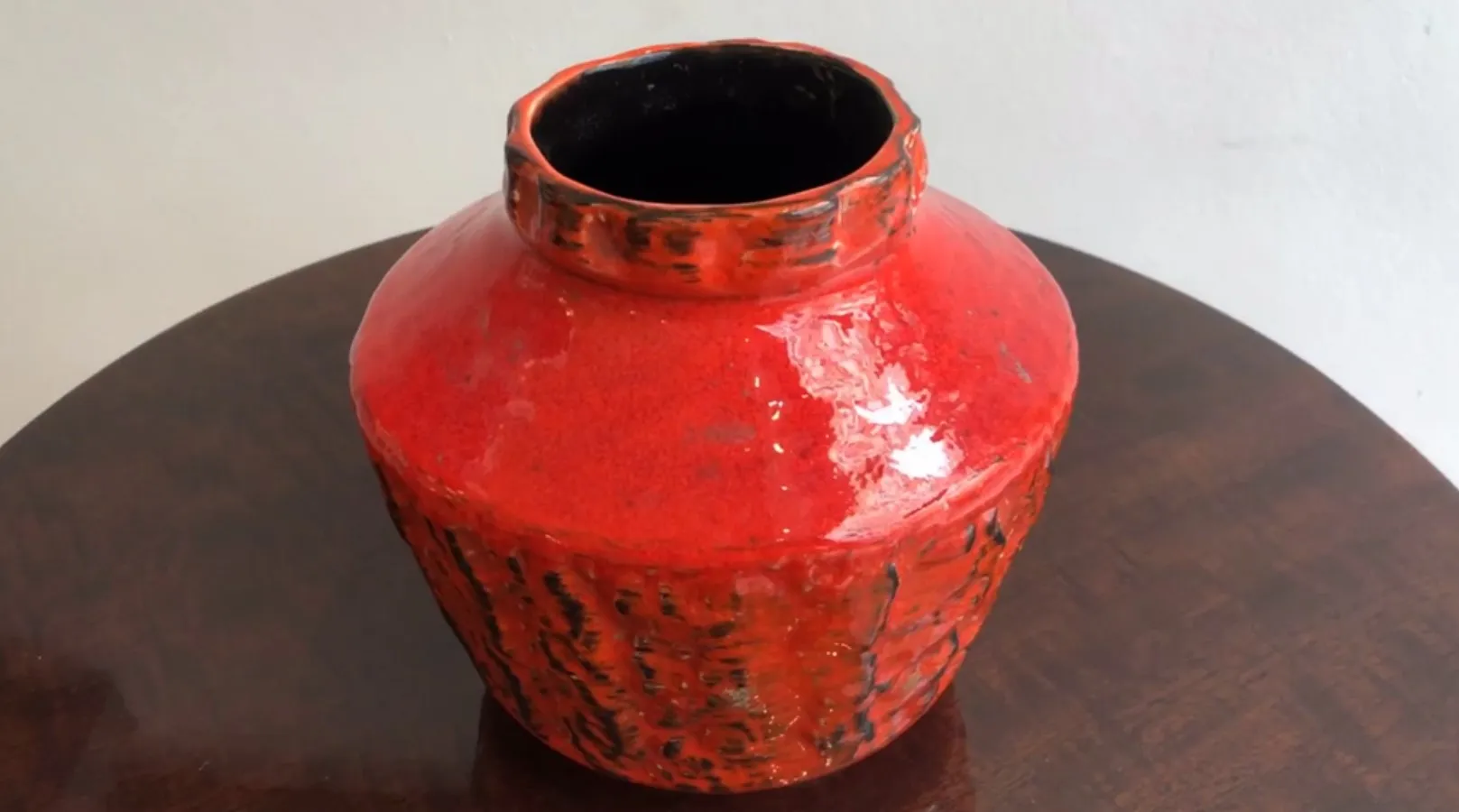 Jarrón de cerámica roja antiguo con textura única.