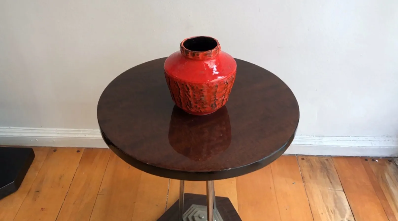 Heller roter antiker Keramikvasen auf einem Tisch.