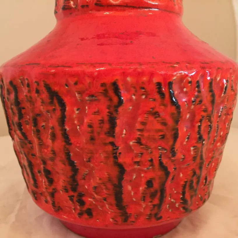 Vase en céramique ancienne, couleur rouge vif avec texture.