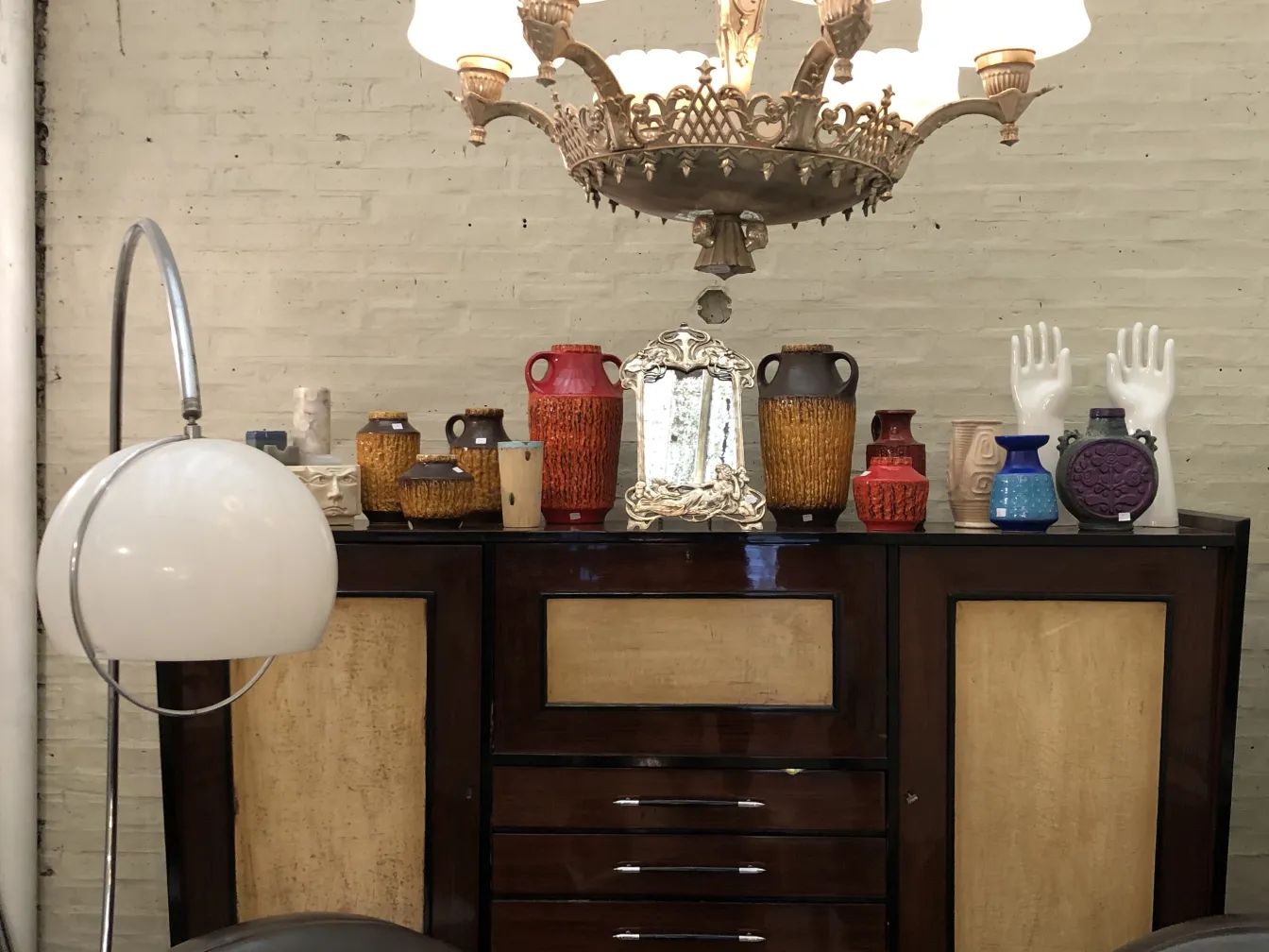 Peças decorativas de cerâmica antiga sobre um bufê escuro, ambiente aconchegante.